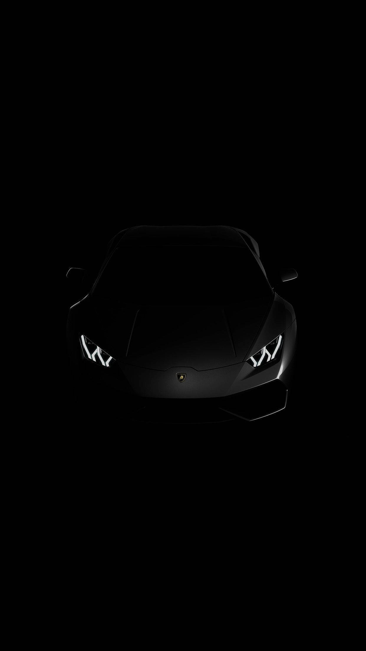 Black Android 桌布 壁紙 — 一架流線型的黑色藍寶堅尼跑車，在漆黑背景中亮起車頭燈，散發光芒。