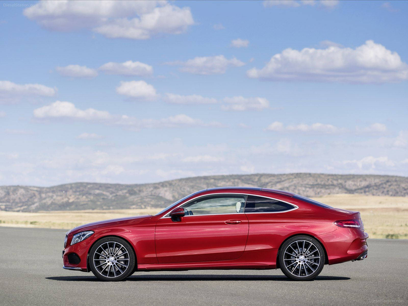 Mercedes Benz C300 桌布 壁紙 — 一架流線型紅色梅賽德斯-賓士轎跑車在沙漠公路上，於藍天白雲下閃耀光芒。