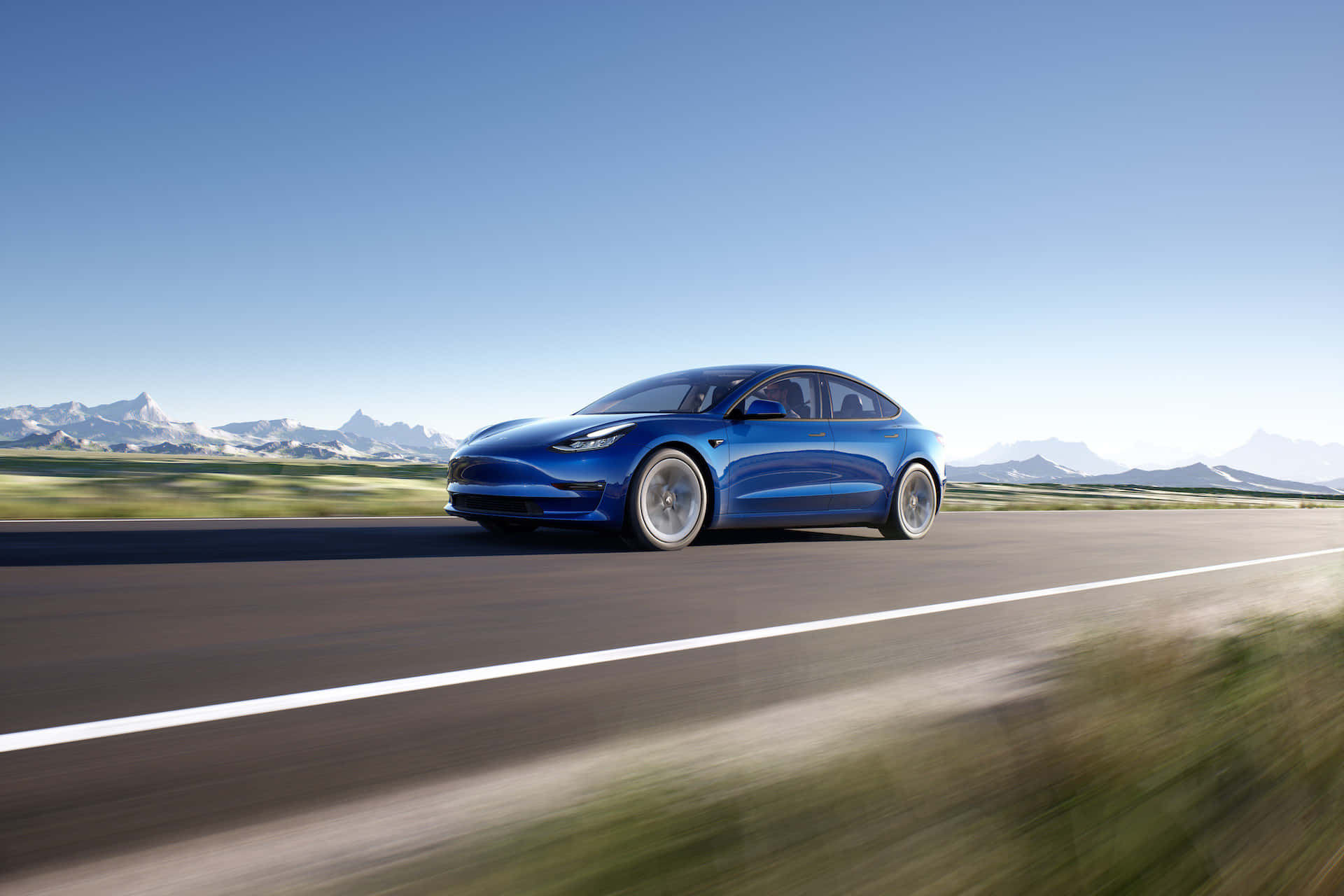 特斯拉 桌布 壁紙 — 一架流線型藍色Tesla Model 3在晴朗藍天下沿著蜿蜒的山路行駛，山峰白雪皚皚。