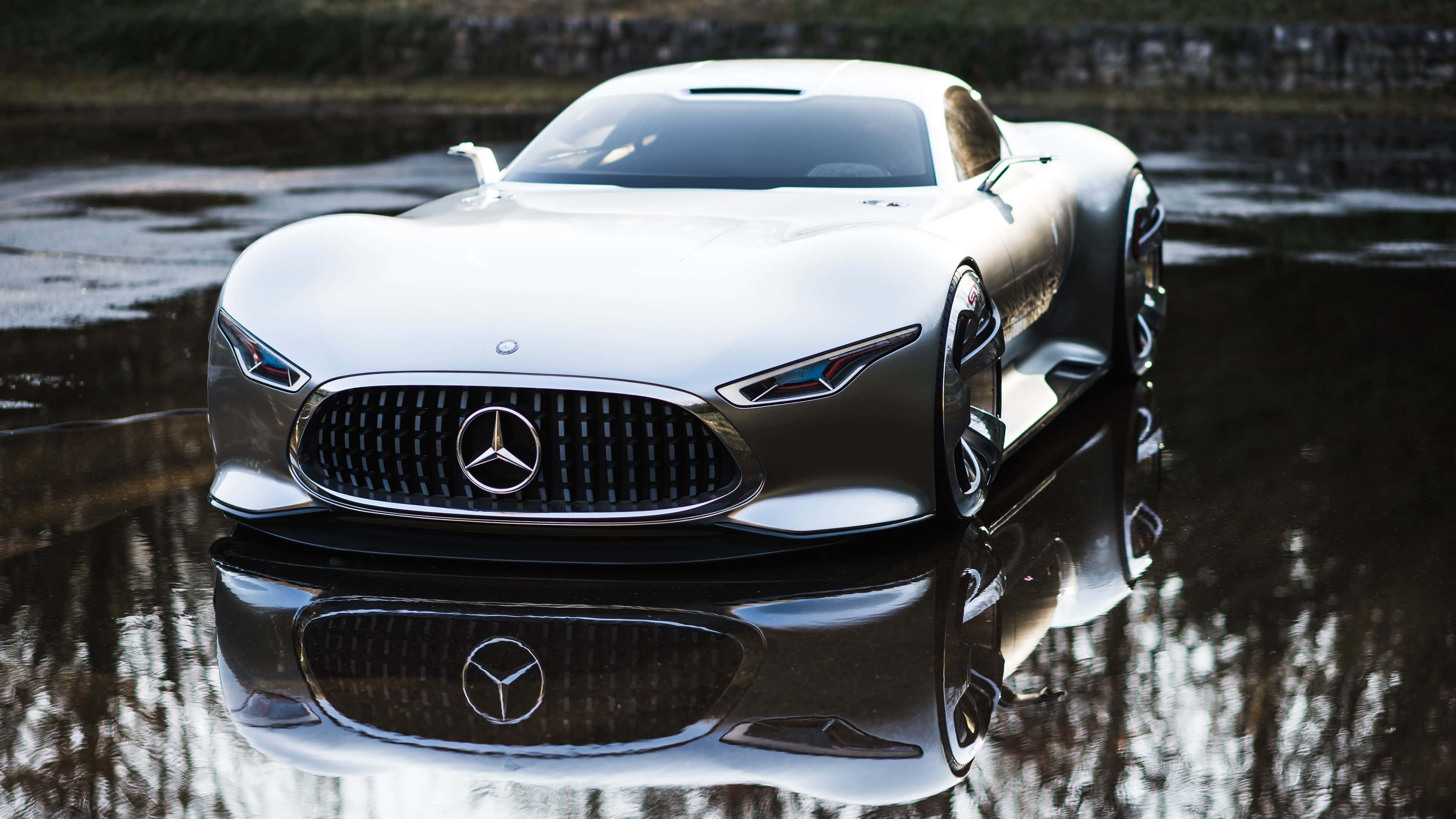 4K 奔馳壁紙 桌布 壁紙 — 一架流線型銀色 Mercedes 概念車在柔和日光下完美倒映在淺水窪中。