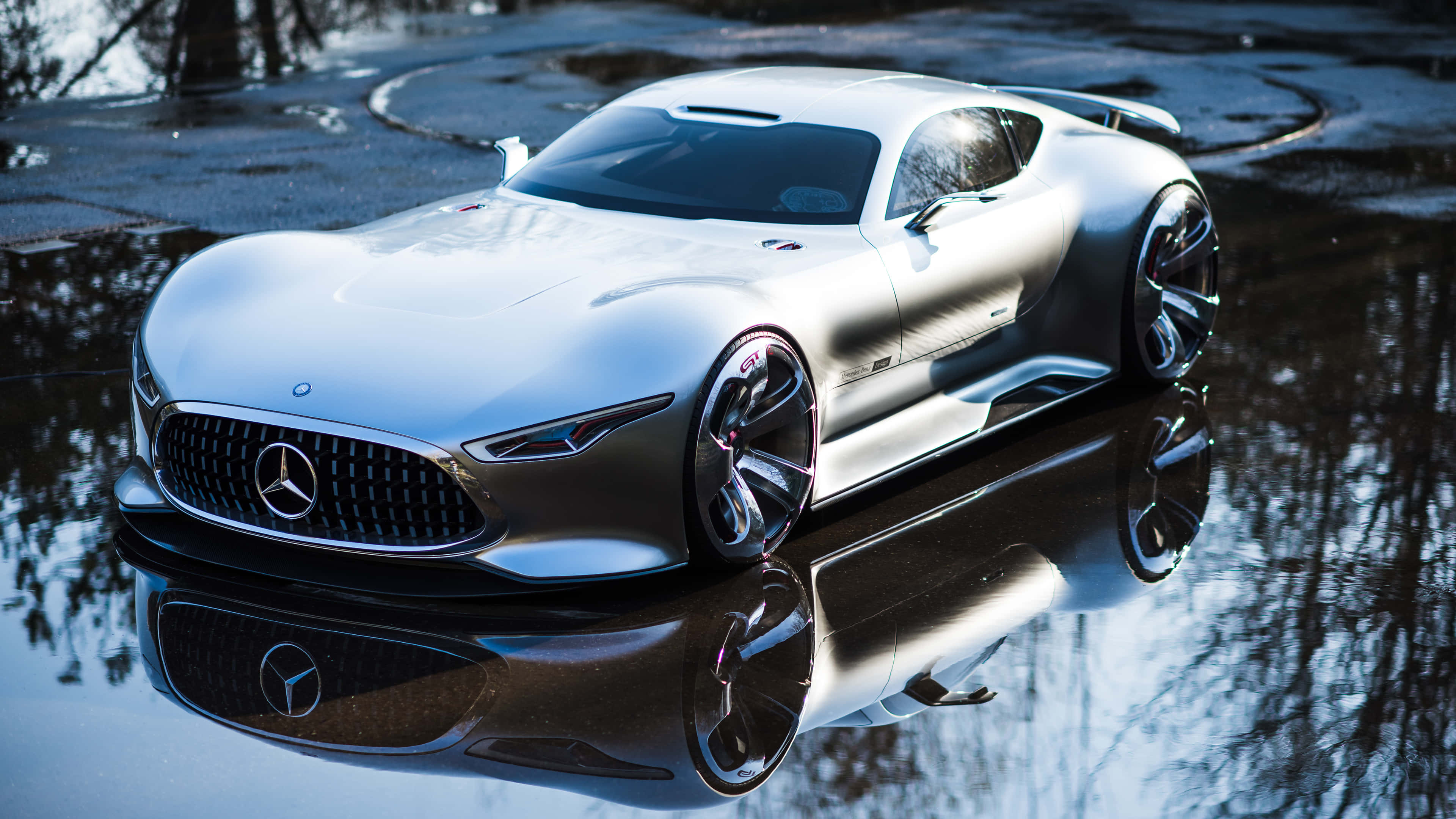 Mercedes Car 4K 桌布 壁紙 — 一架流線型銀色 Mercedes 跑車在清涼日光下完美倒映在濕瀝青水坑中。
