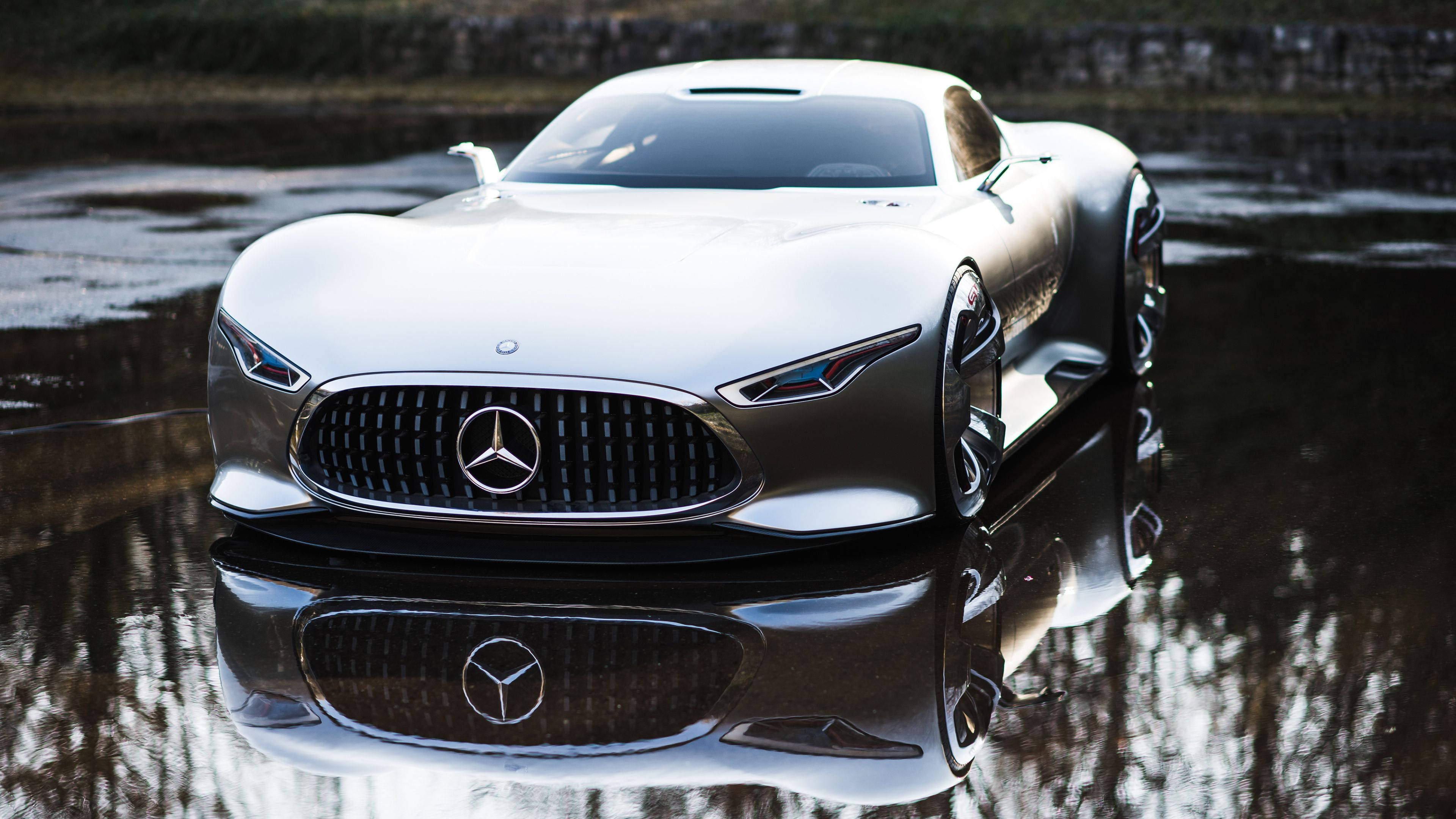 benz 4K 桌布 壁紙 — 一架流線型銀色 Mercedes 概念車在柔和日光下完美倒映在淺水窪中。