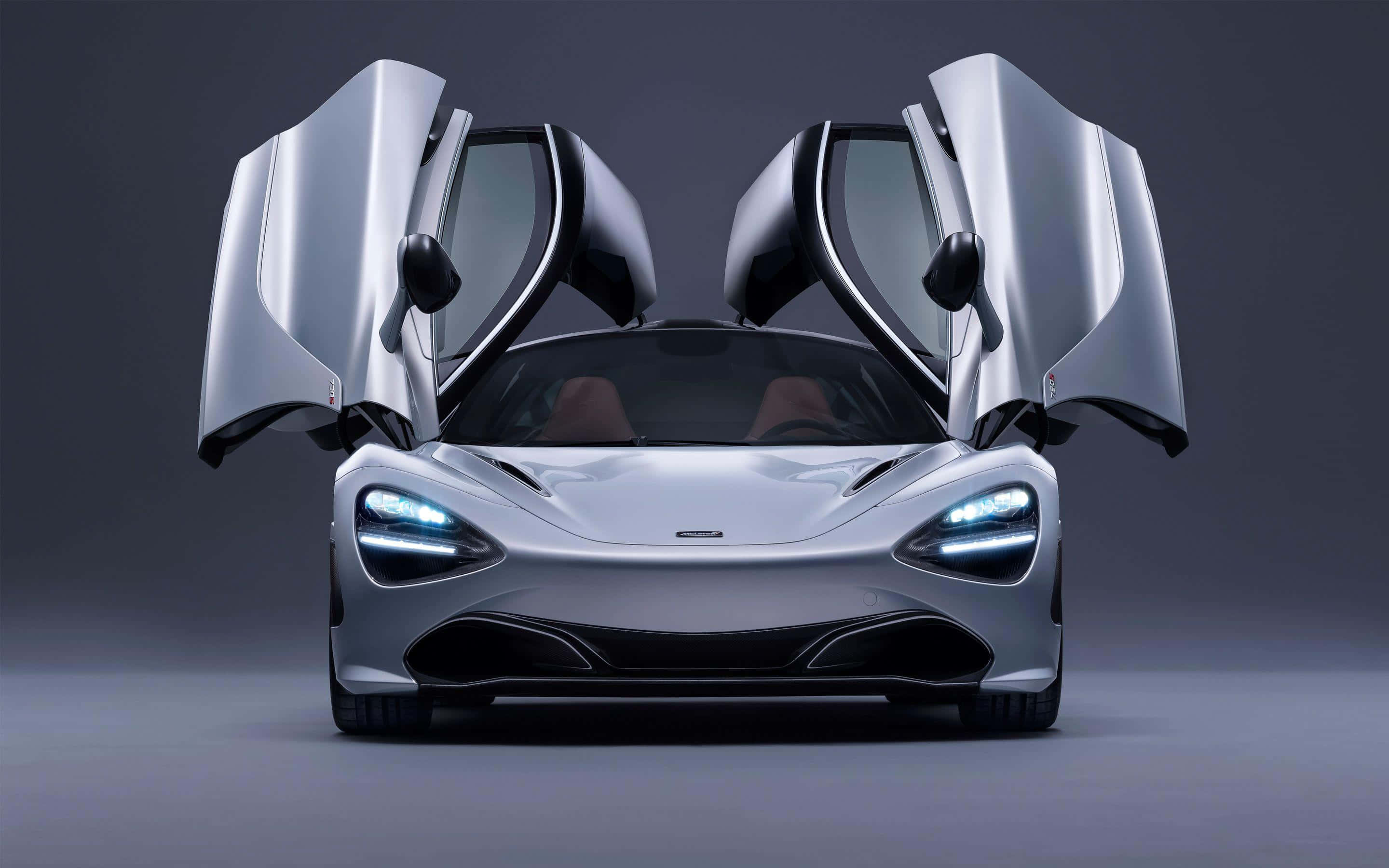 麥拉倫 720S 桌布 壁紙 — 一架流線型銀色McLaren跑車，鷗翼車門打開，襯托深色工作室背景。