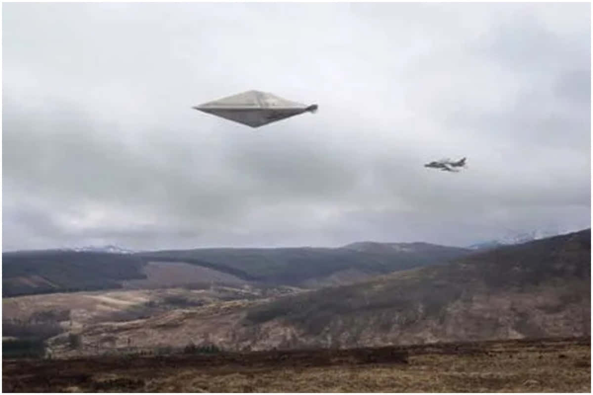  壁紙 — 一架流線型銀色UFO盤旋在崎嶇的山谷上方，一架戰鬥機在陰天附近飛行。