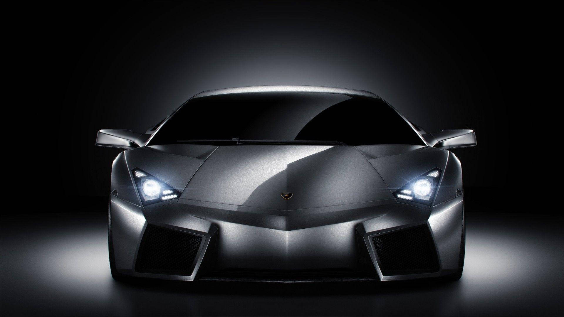Lamborghini 4K 桌布 壁紙 — 一架流線型銀色藍寶堅尼跑車在黑色背景下的戲劇性攝影棚燈光中閃耀。