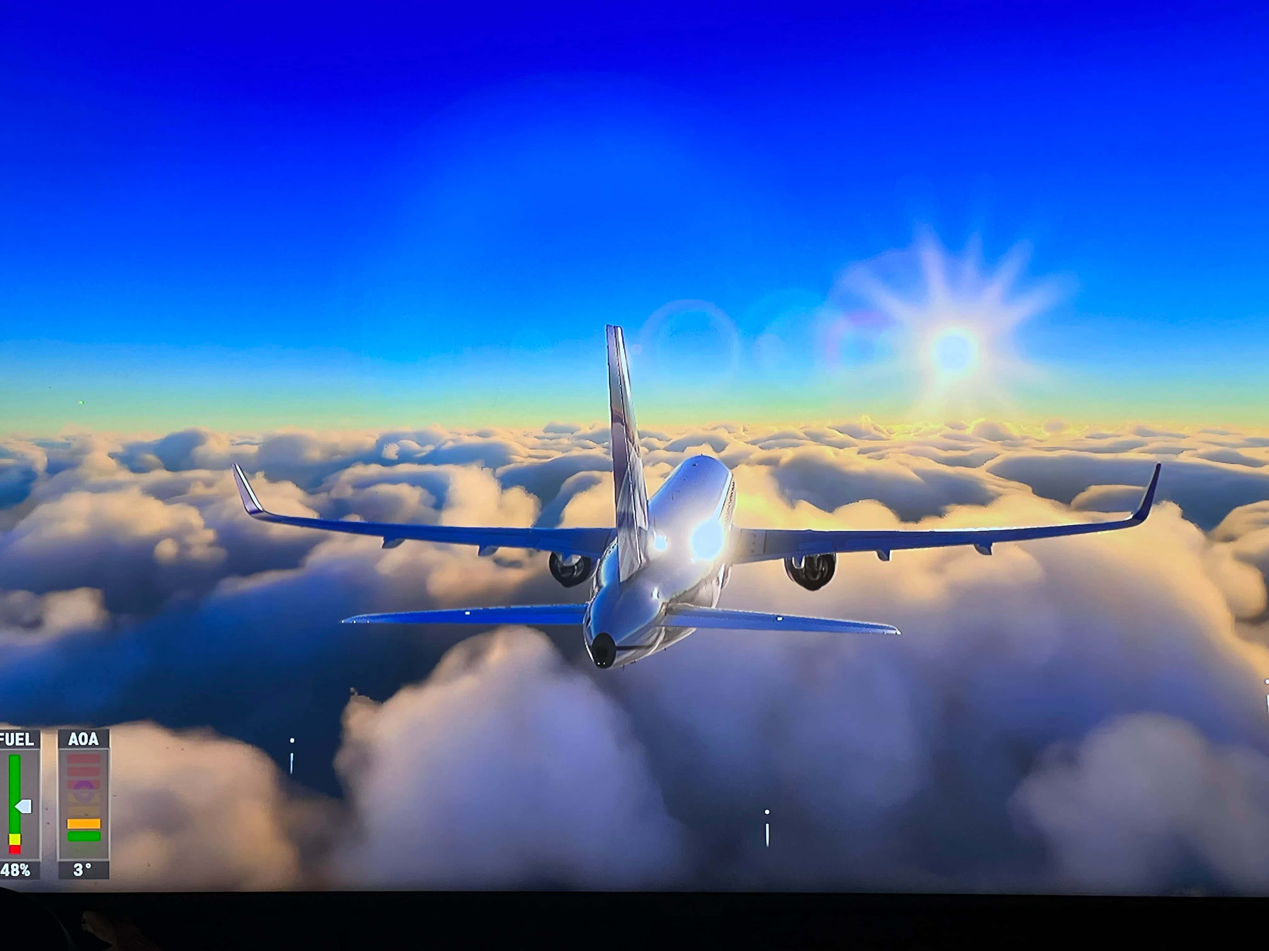 電玩遊戲 桌布 壁紙 — 一架流線型飛機翱翔於蓬鬆雲層之上，燦爛的太陽在鮮豔的藍天中明亮照耀。