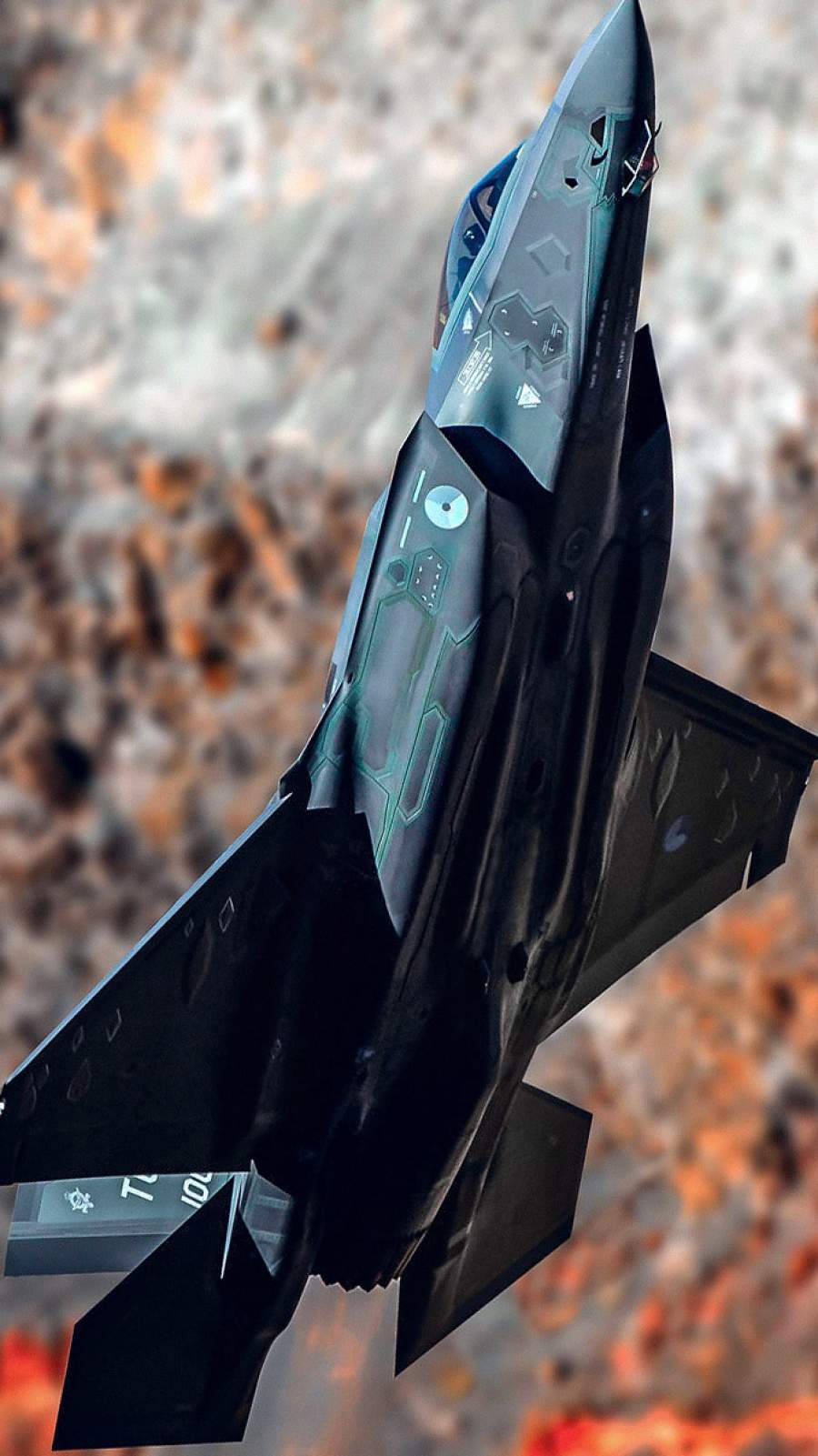 Air Force 桌布 壁紙 — 一架流線型黑色隱形戰鬥機在崎嶇岩石地形上方翱翔，帶有發光綠色電路裝飾。