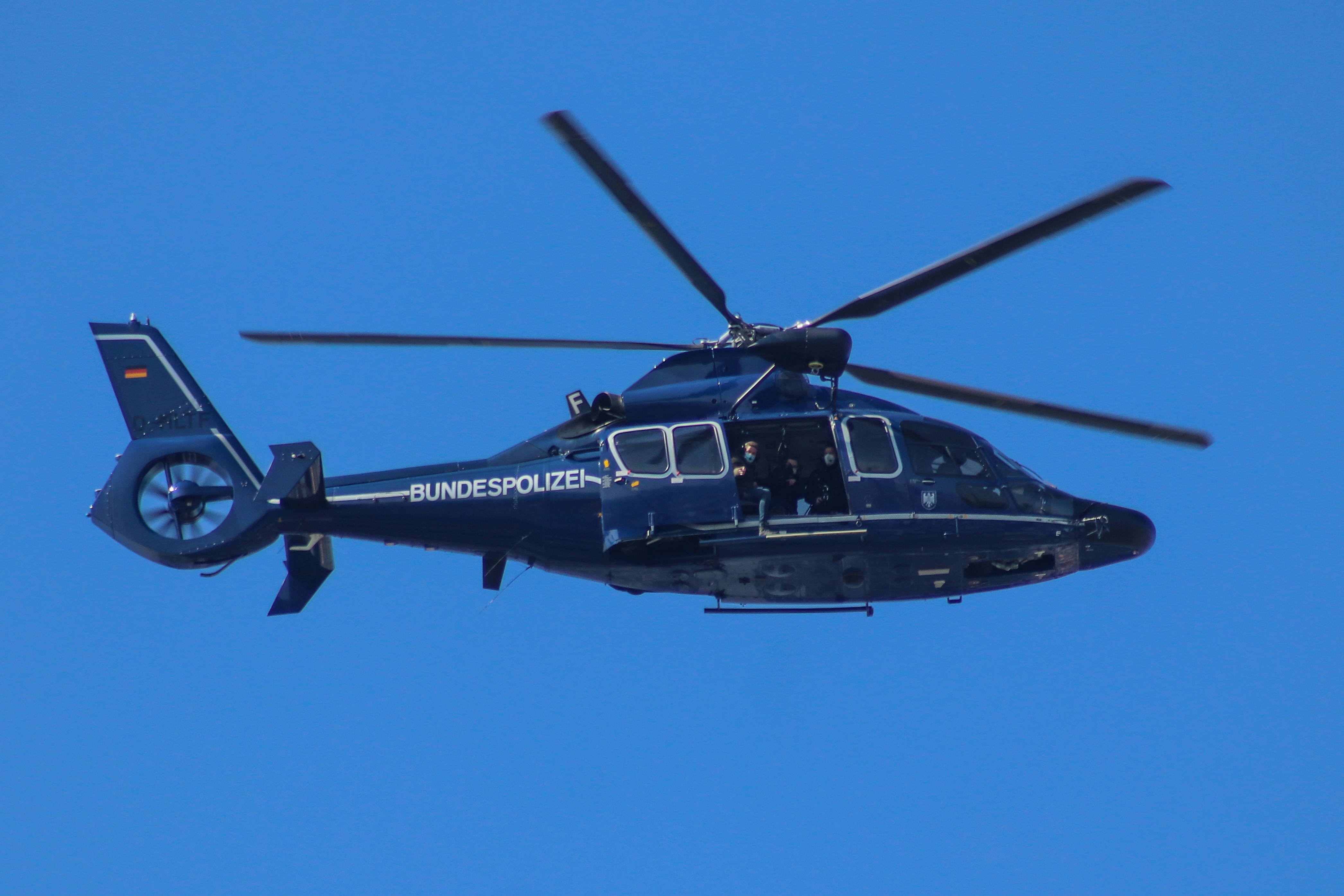 Helicopter 桌布 壁紙 — 一架深藍色的聯邦警察直升機在晴朗明亮的藍天中翱翔，旋翼轉動。