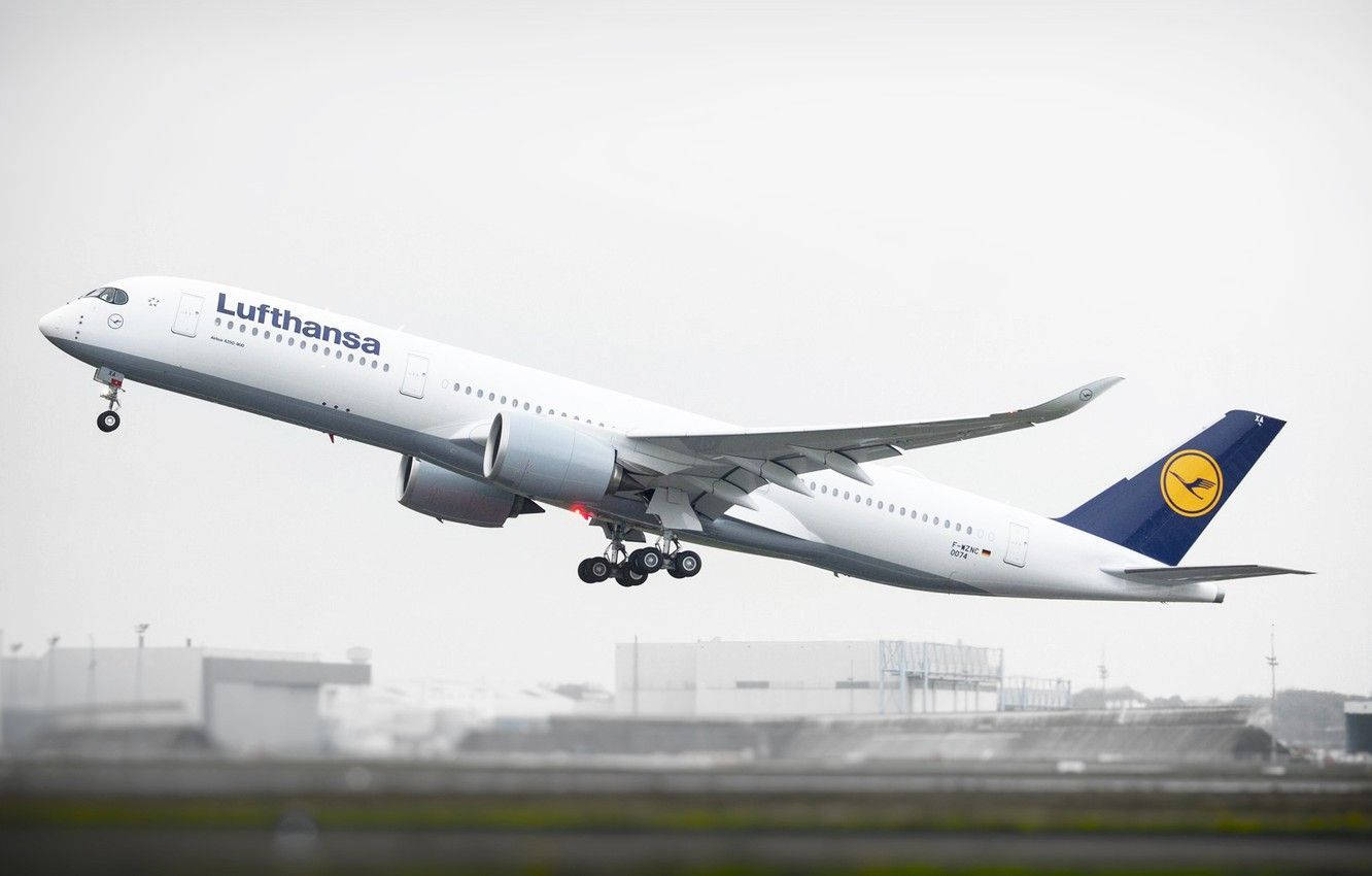 飛機 桌布 壁紙 — 一架漢莎航空空中巴士A350在灰色多雲的天空下收起起落架起飛。