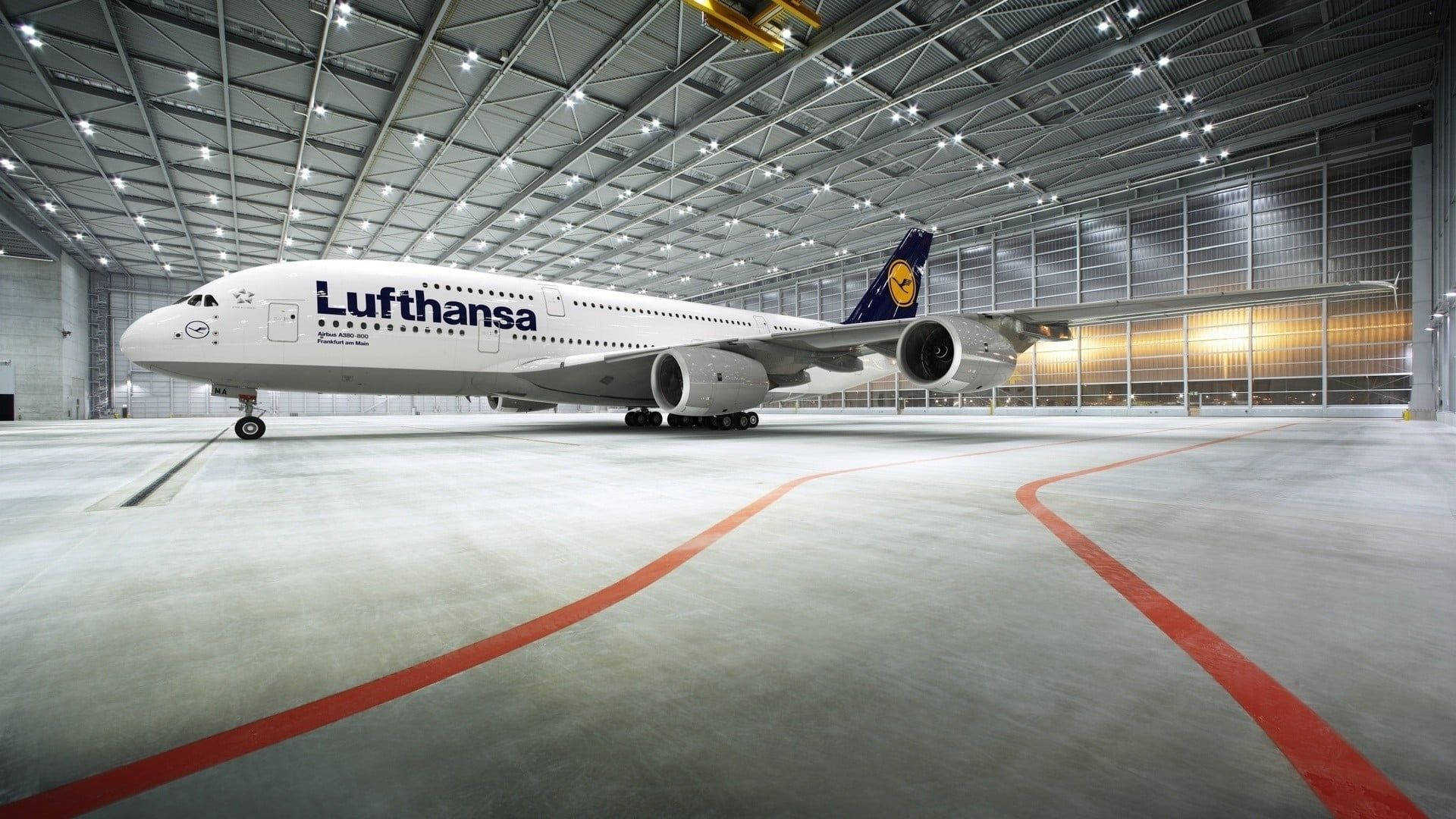 飛機 桌布 壁紙 — 一架漢莎航空空中巴士A380停放在寬敞明亮、帶有紅色地板標記的飛機庫內。