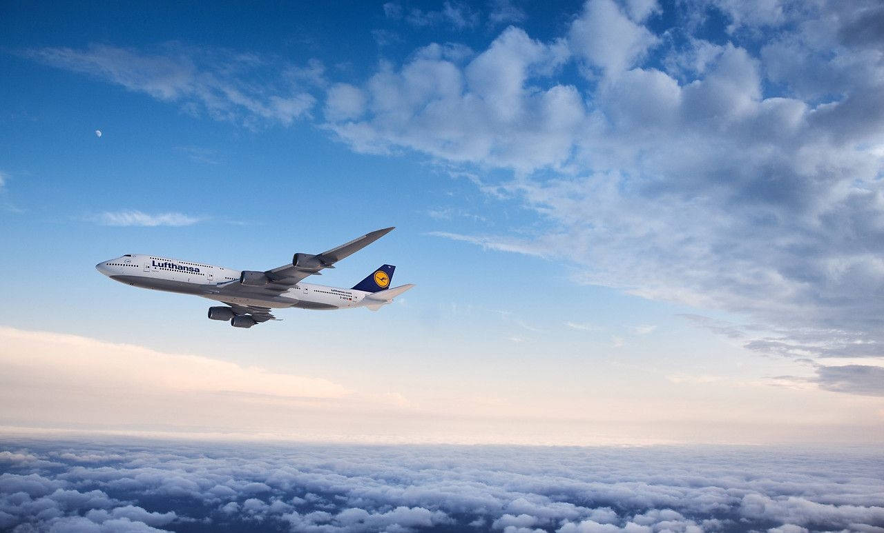 雲朵 桌布 壁紙 — 一架漢莎航空空中巴士A380在廣闊藍天下優雅地翱翔於蓬鬆白雲之上，可見月亮。