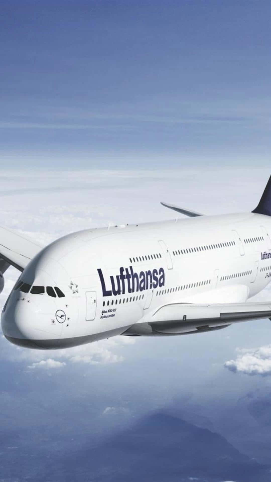 Plane 桌布 壁紙 — 一架漢莎航空空中巴士A380在藍天背景下翱翔於蓬鬆的白雲之上，下方遠處有山脈。
