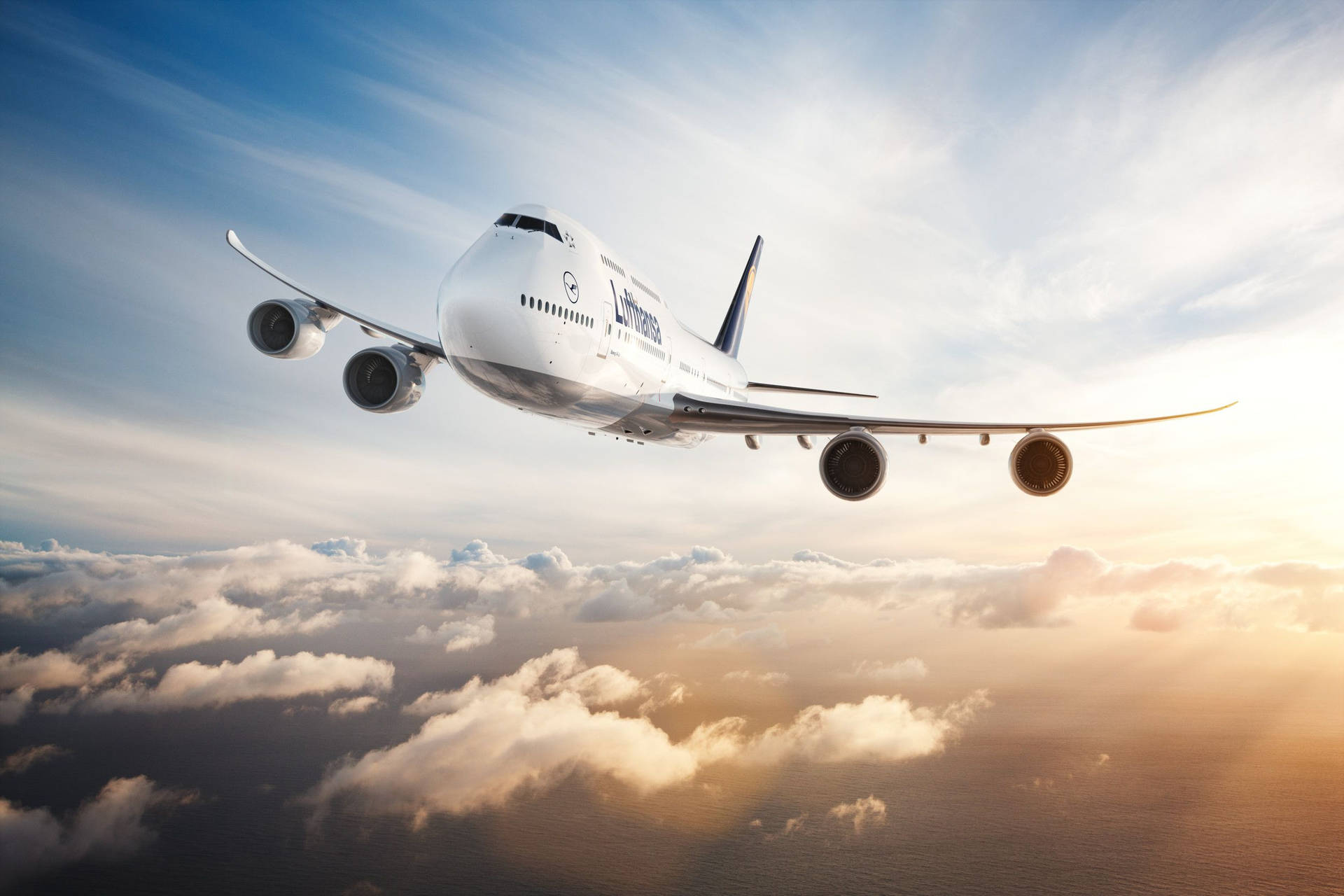  壁紙 — 一架漢莎航空空中巴士A380在藍天背景下，翱翔於沐浴在金色夕陽中的蓬鬆雲層之上。