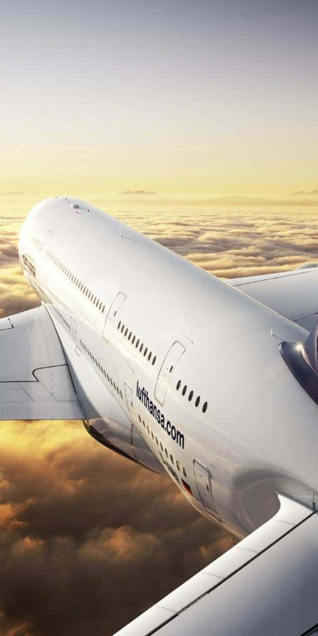 Pixel 3 Plane 桌布 壁紙 — 一架漢莎航空飛機在日出時翱翔於金色雲層之上，柔和溫暖的光線沐浴著機身。