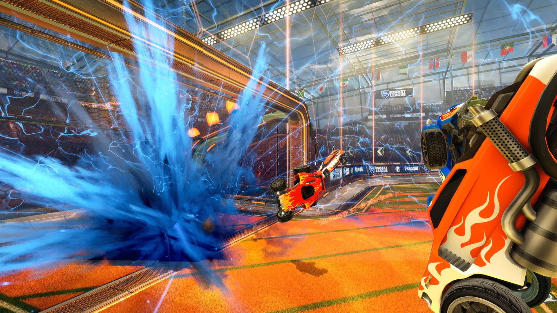 1080p Rocket League 桌布 壁紙 — 一架火熱的橙色火箭車在充滿活力的室內賽車場中，於電光藍色能量爆發中凌空翻轉。