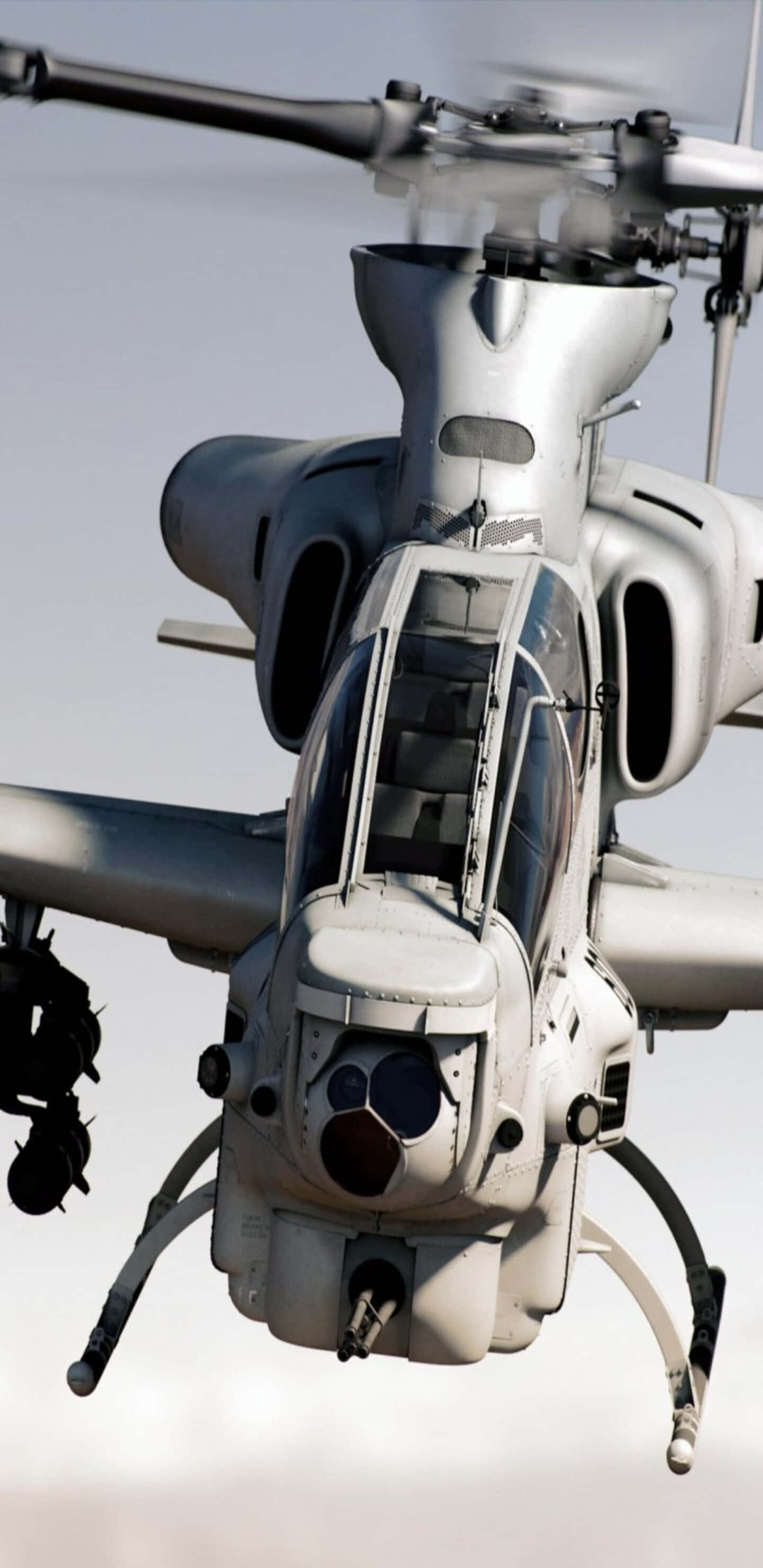 Helicopter 桌布 壁紙 — 一架灰色軍用攻擊直升機在蒼白天空中盤旋的特寫視角。