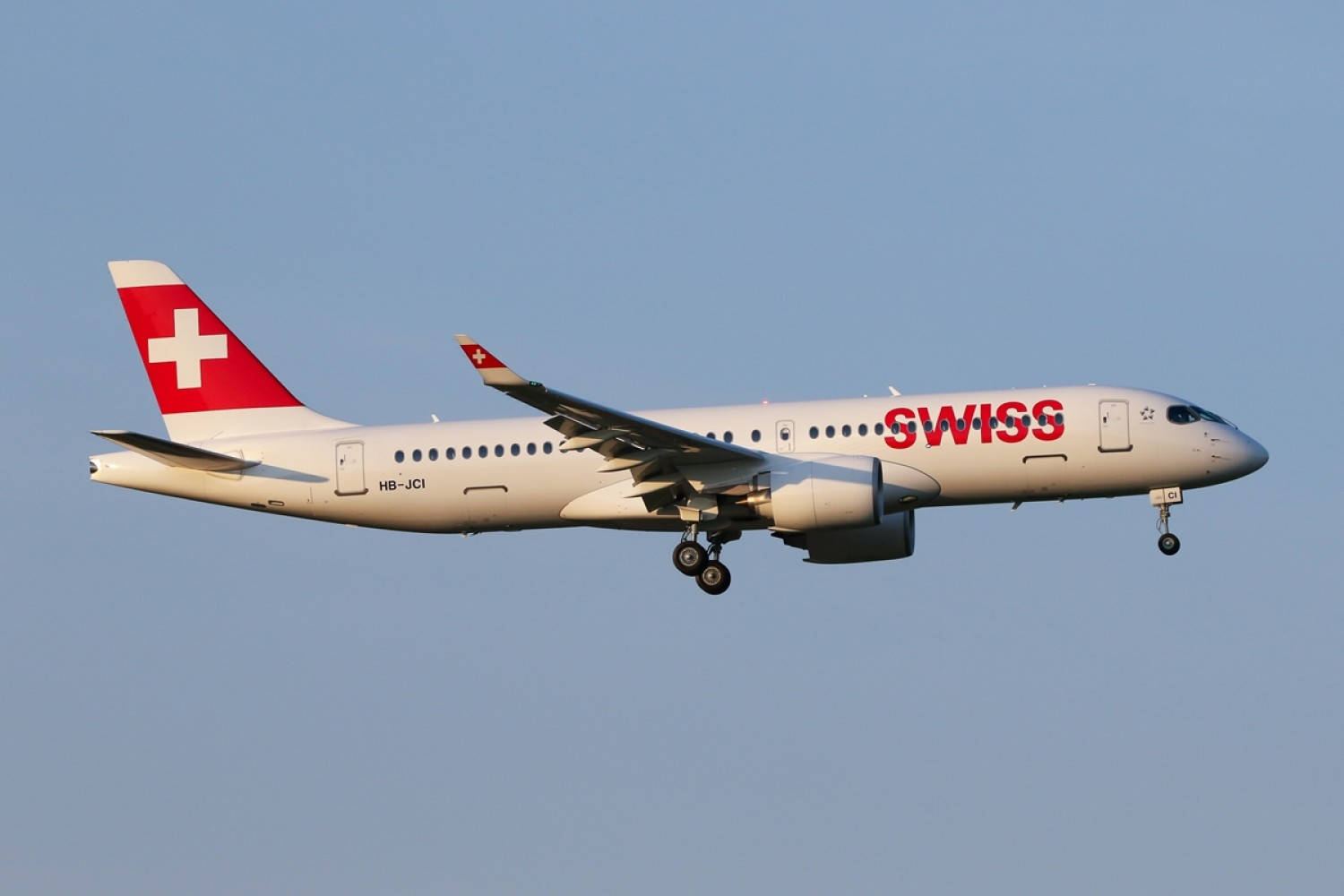 瑞士 桌布 壁紙 — 一架瑞士航空公司的客機放下起落架，在白天晴朗的藍天中翱翔。