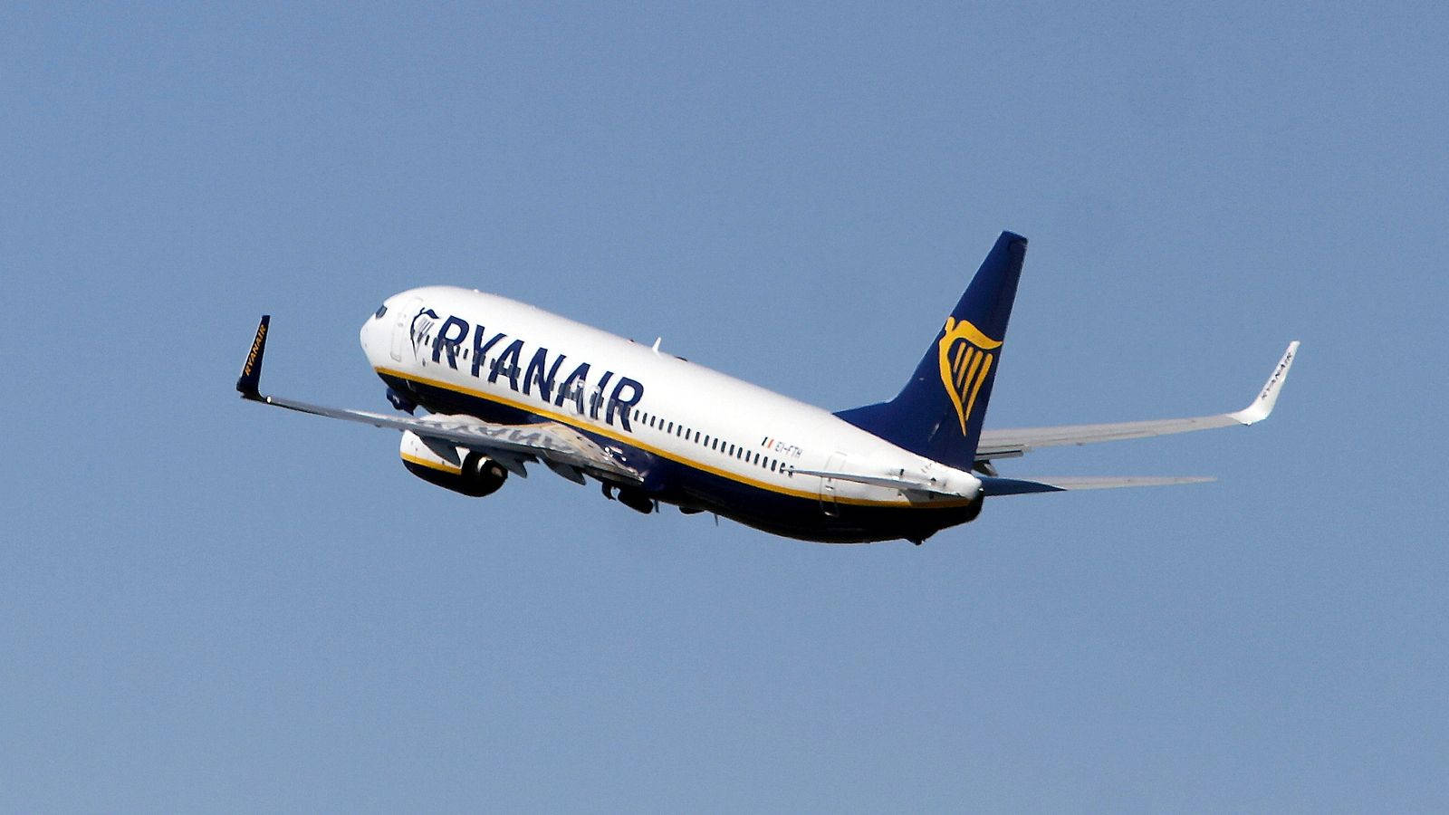 飛機 桌布 壁紙 — 一架瑞安航空客機在晴朗的藍天中翱翔，起落架已放下。