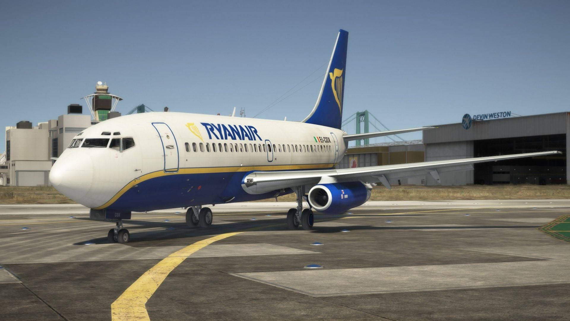 飛機 桌布 壁紙 — 一架瑞安航空波音737停放在陽光明媚的機場停機坪上，背景有黃色的滑行道線和航廈建築。