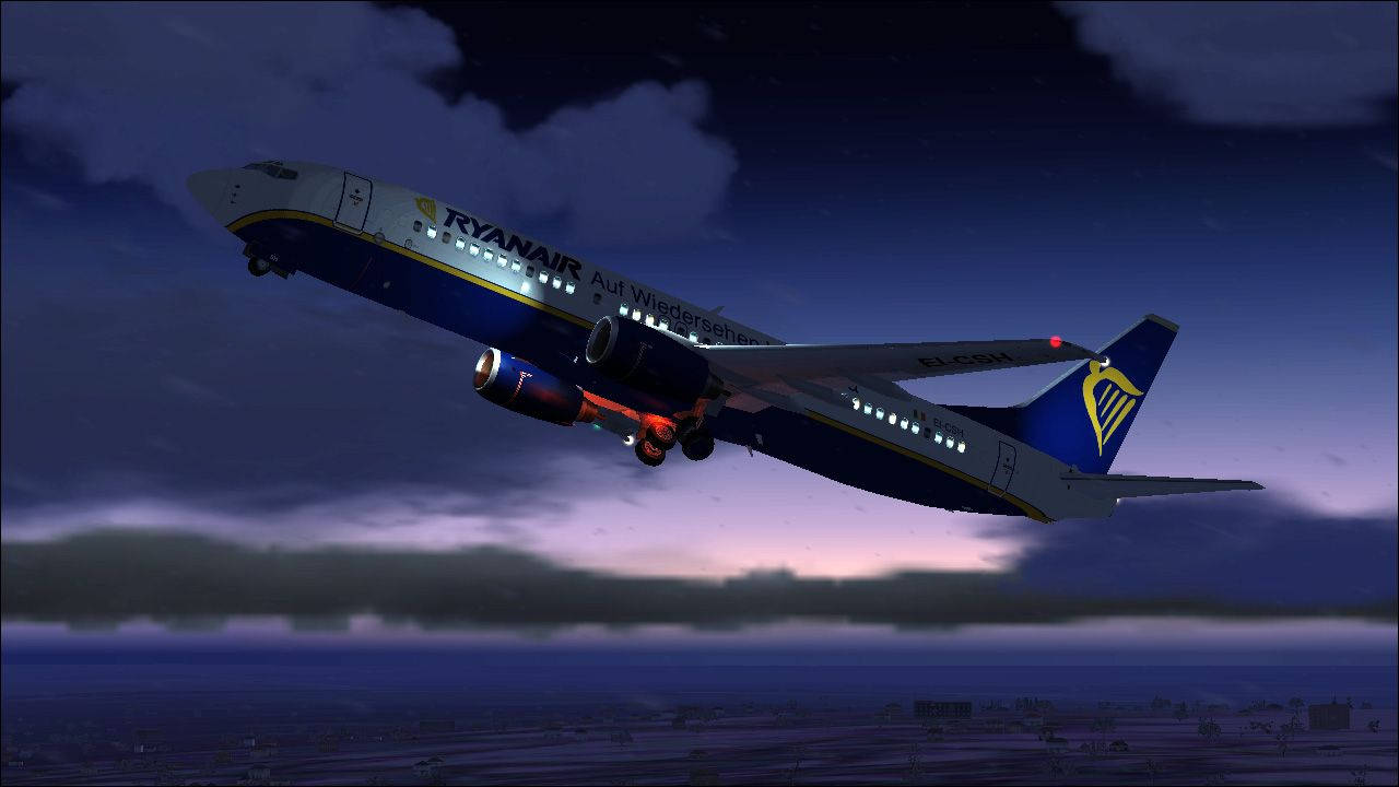 飛機 桌布 壁紙 — 一架瑞安航空飛機在暮色雲層中下降，降落燈在遠處的城市景觀上空閃爍。