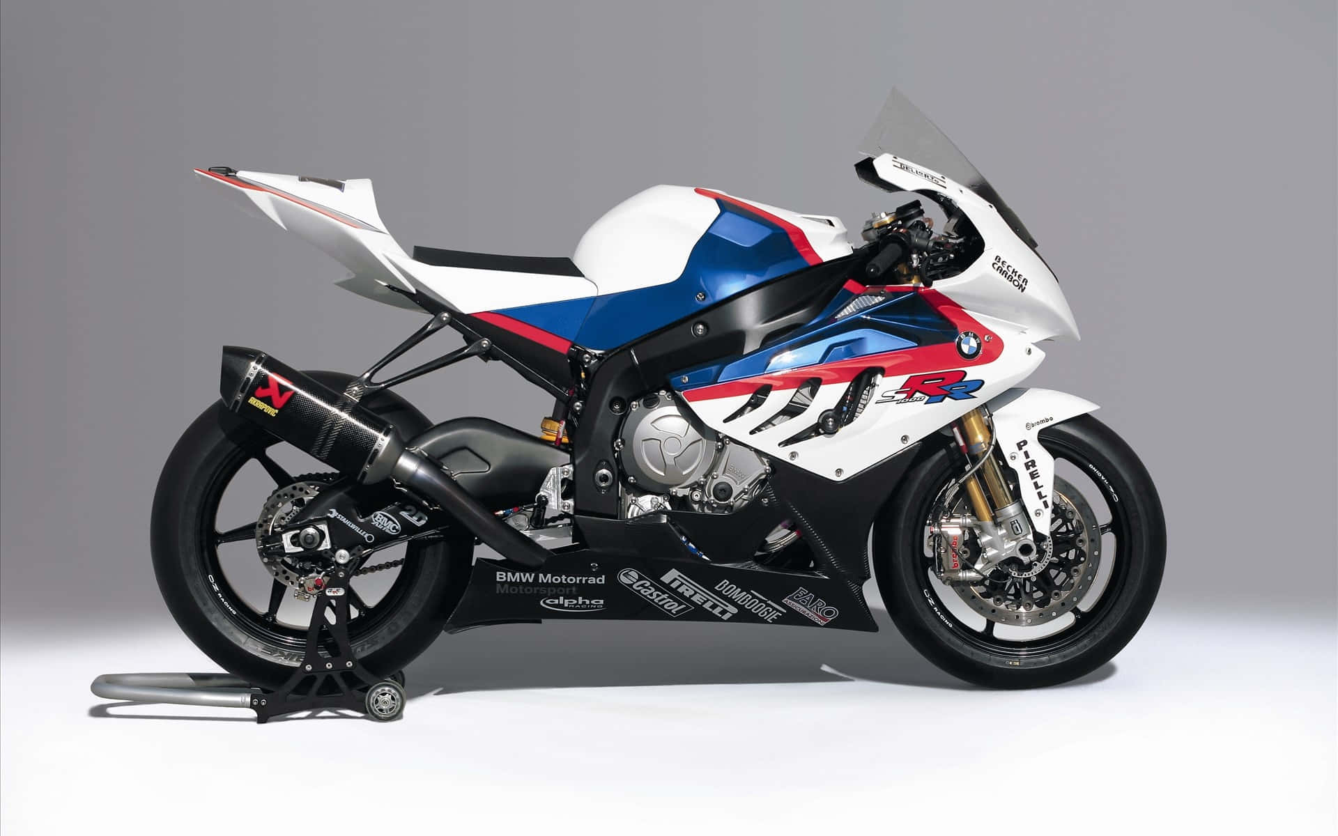 Superbike 桌布 壁紙 — 一架白色、藍色和紅色的BMW賽車摩托車優雅地立在支架上，背景是中性灰色攝影棚。