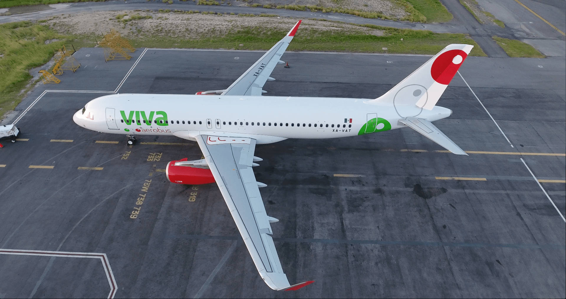飛機 桌布 壁紙 — 一架白色Viva Aerobus空中巴士噴射機停泊在停機坪上的鳥瞰圖，帶有紅色點綴和綠色品牌標誌。
