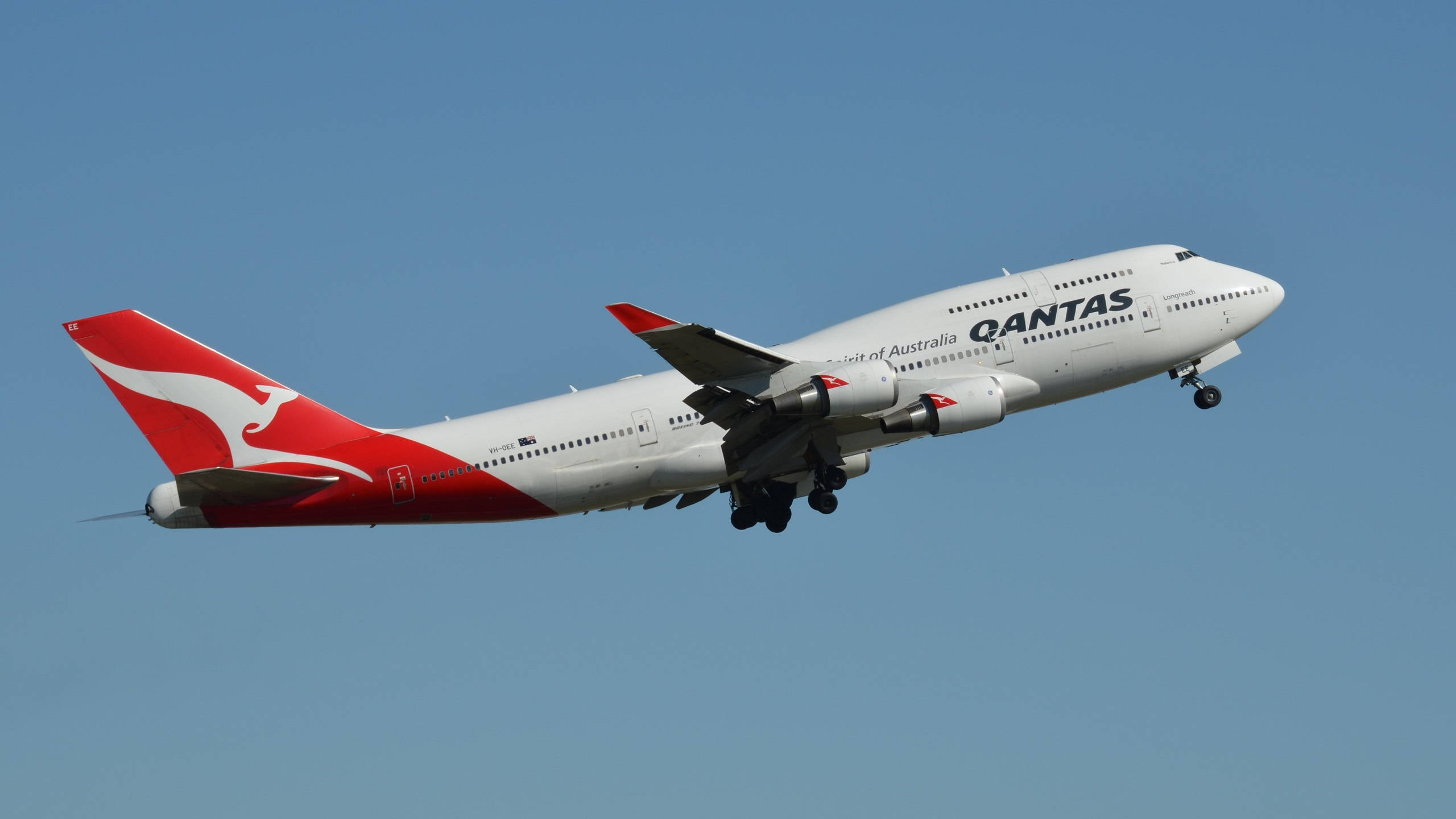 Plane 桌布 壁紙 — 一架白色和紅色塗裝的澳洲航空波音747飛機，在起落架放下的情況下，向著清澈的藍天爬升。