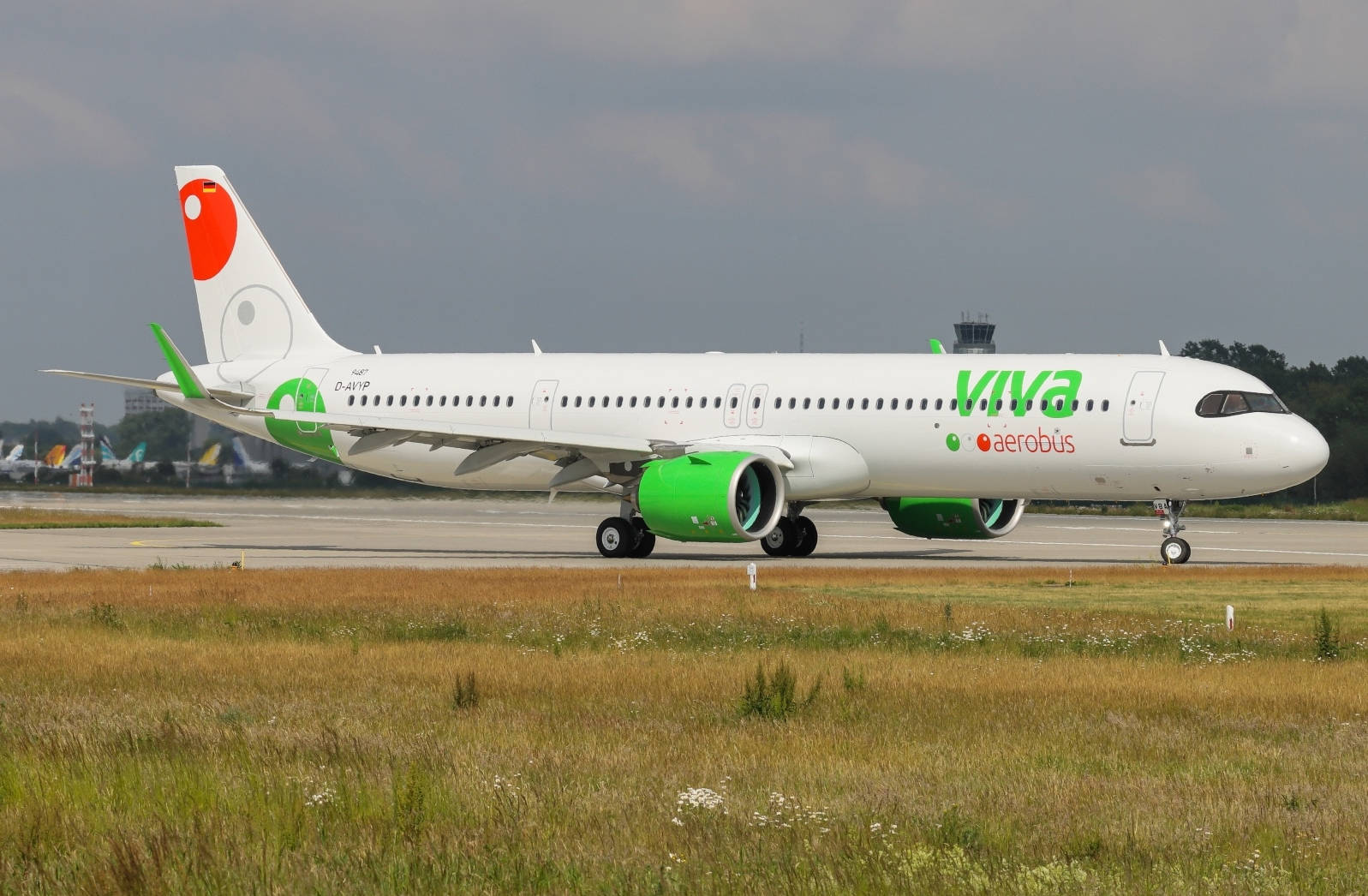 飛機 桌布 壁紙 — 一架白色和綠色的Viva Aerobus空中巴士A320在跑道上滑行，背景是草地和陰天。