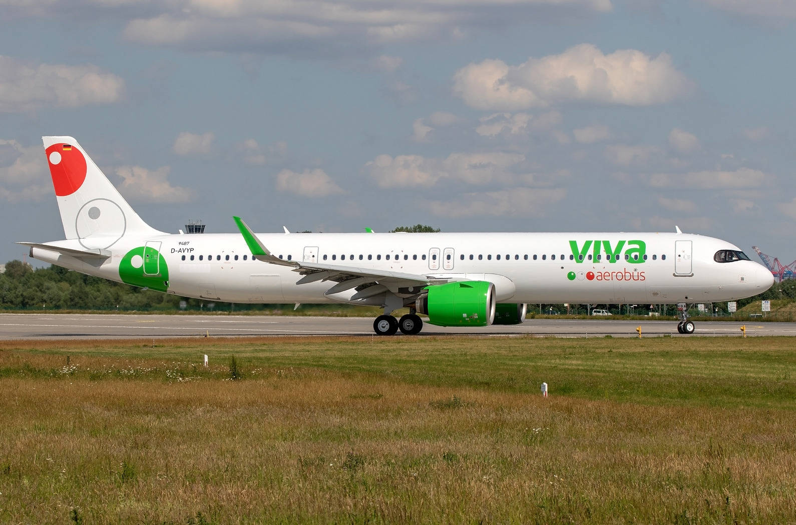 飛機 桌布 壁紙 — 一架白色和綠色的Viva Aerobus空中巴士A320在部分多雲的天空下滑行，附近有草地。