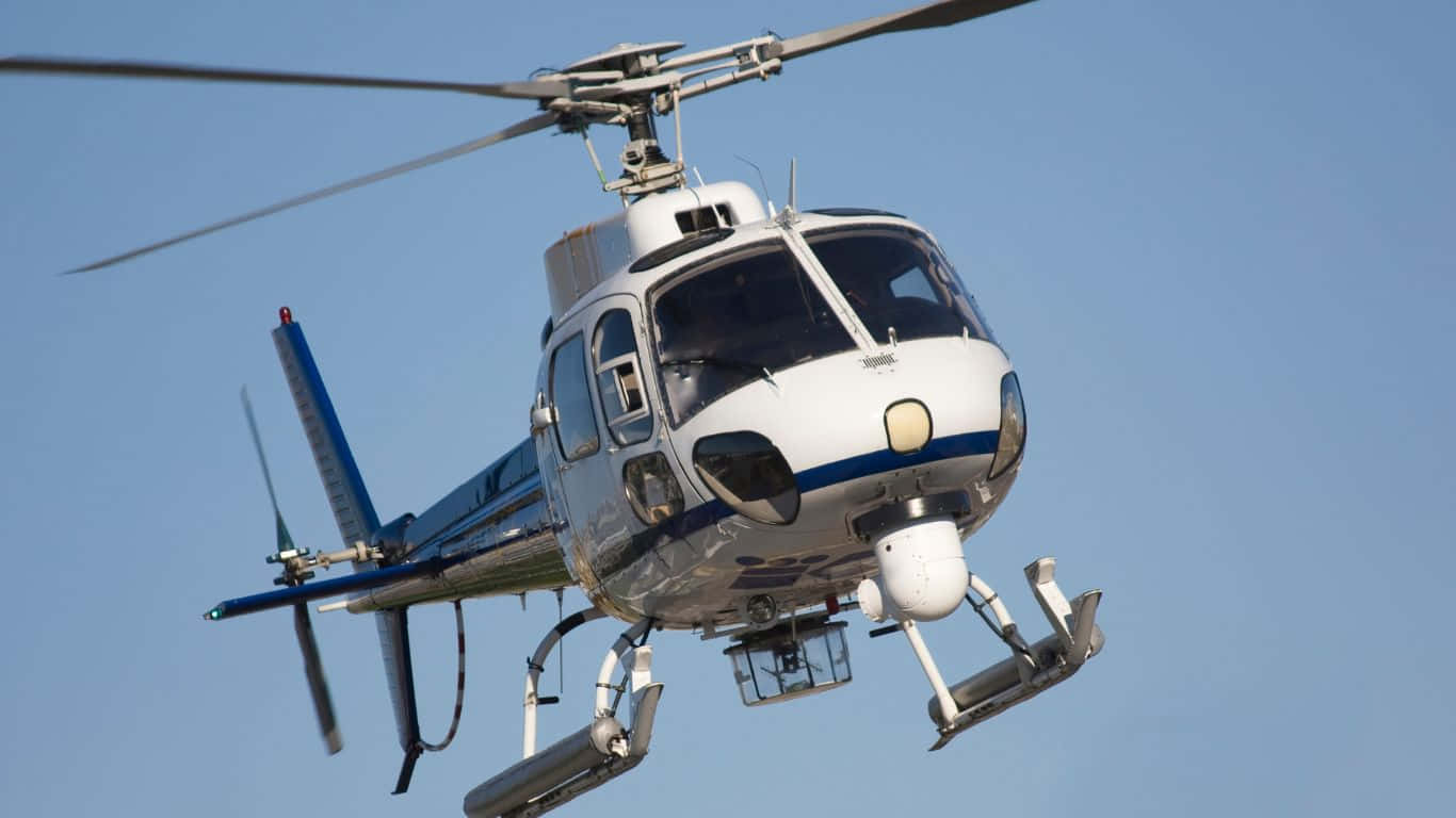 1366x768 Helicopters 桌布 壁紙 — 一架白色和藍色的直升機帶有滑雪板，在晴朗的藍天中盤旋。