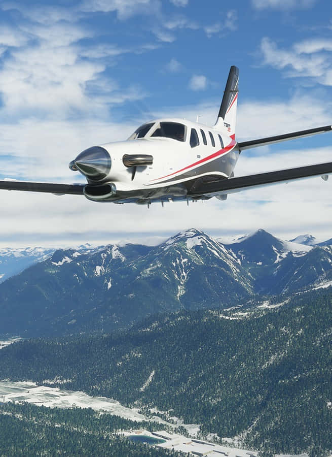 Android Microsoft Flight Simulator 桌布 壁紙 — 一架白色單引擎螺旋槳飛機在明亮的藍天和零星雲朵下，翱翔於積雪的山峰之上。