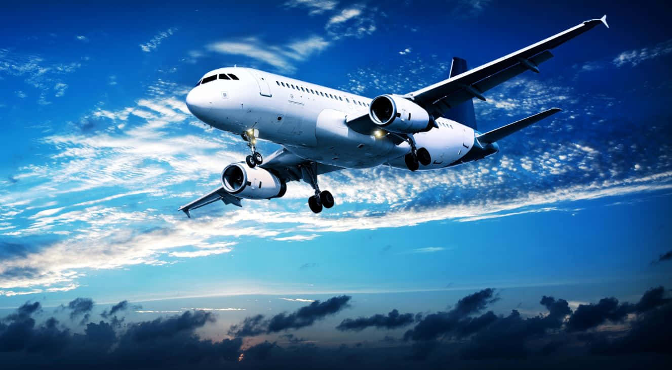 Flight 桌布 壁紙 — 一架白色客機在充滿活力的藍天中下降，天空中有縷縷薄雲和下方的暗色雲層。