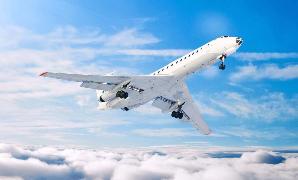 Flight 桌布 壁紙 — 一架白色客機在明亮的藍天和薄雲下翱翔於蓬鬆的白雲之上。