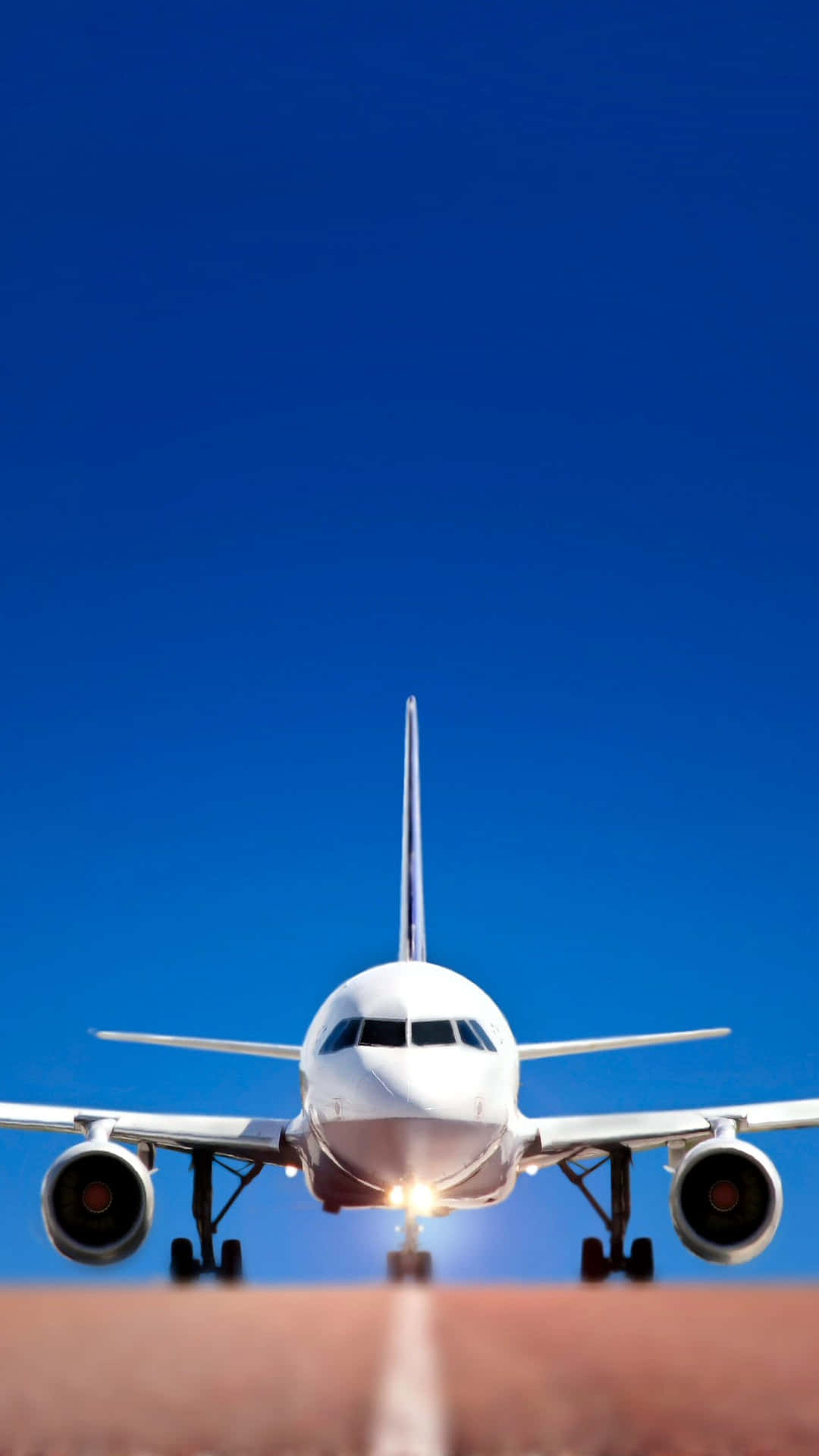Plane 桌布 壁紙 — 一架白色客機在晴朗的藍天下接近跑道，降落燈閃爍著光芒。