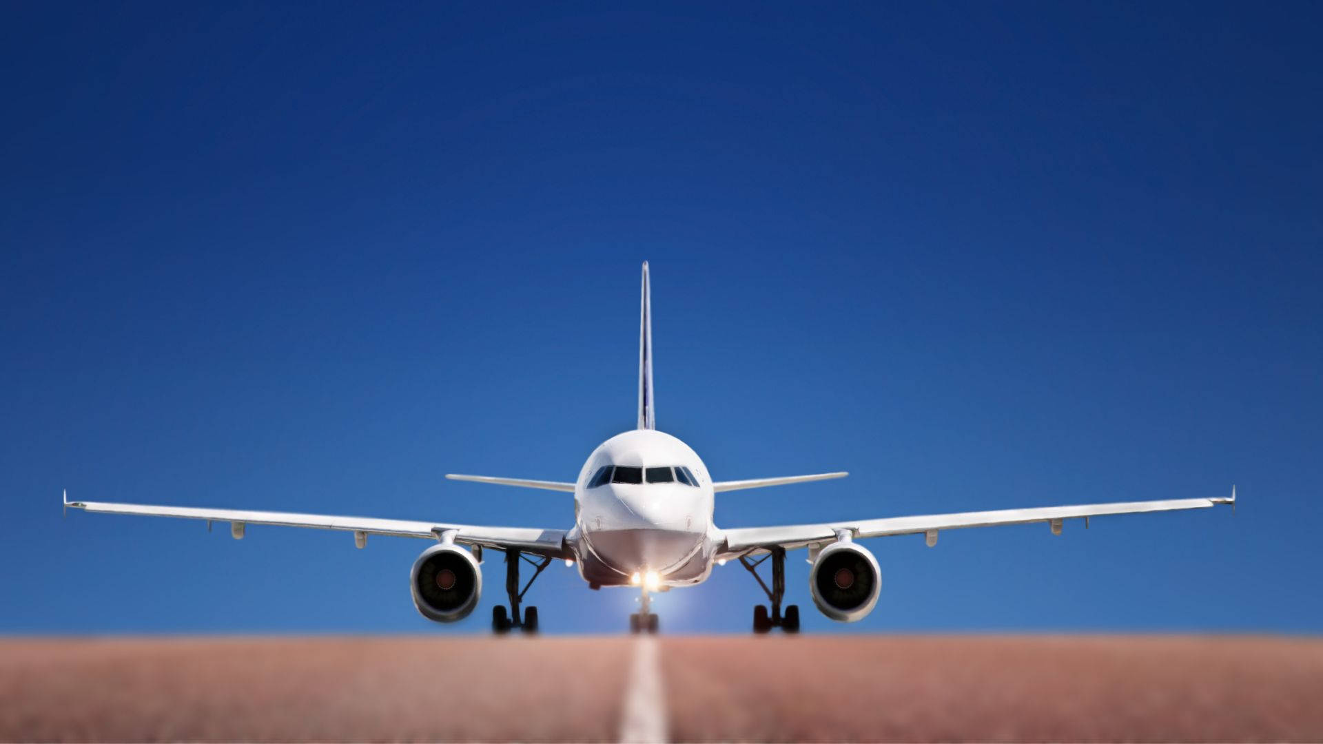 Runway 桌布 壁紙 — 一架白色客機在晴朗的藍天下接近跑道，降落燈閃爍著光芒。