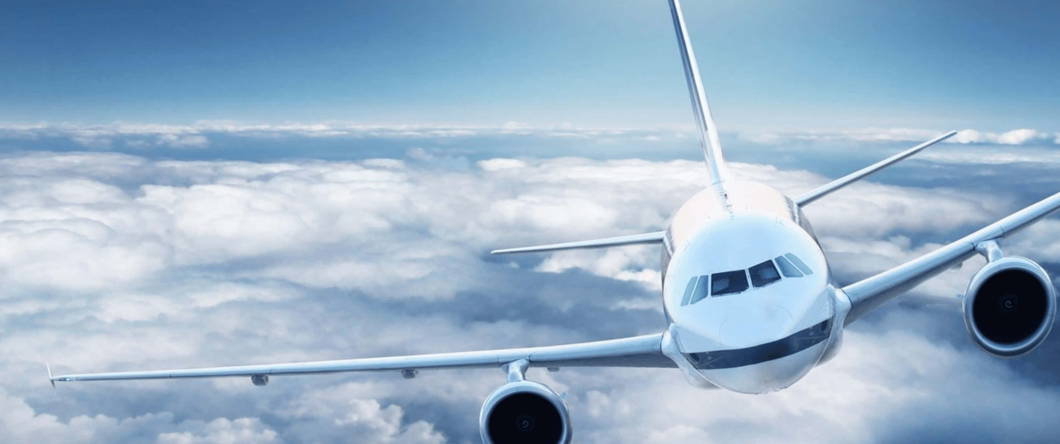 Plane 桌布 壁紙 — 一架白色客機在晴朗的藍天下翱翔於無盡的蓬鬆雲層之上。