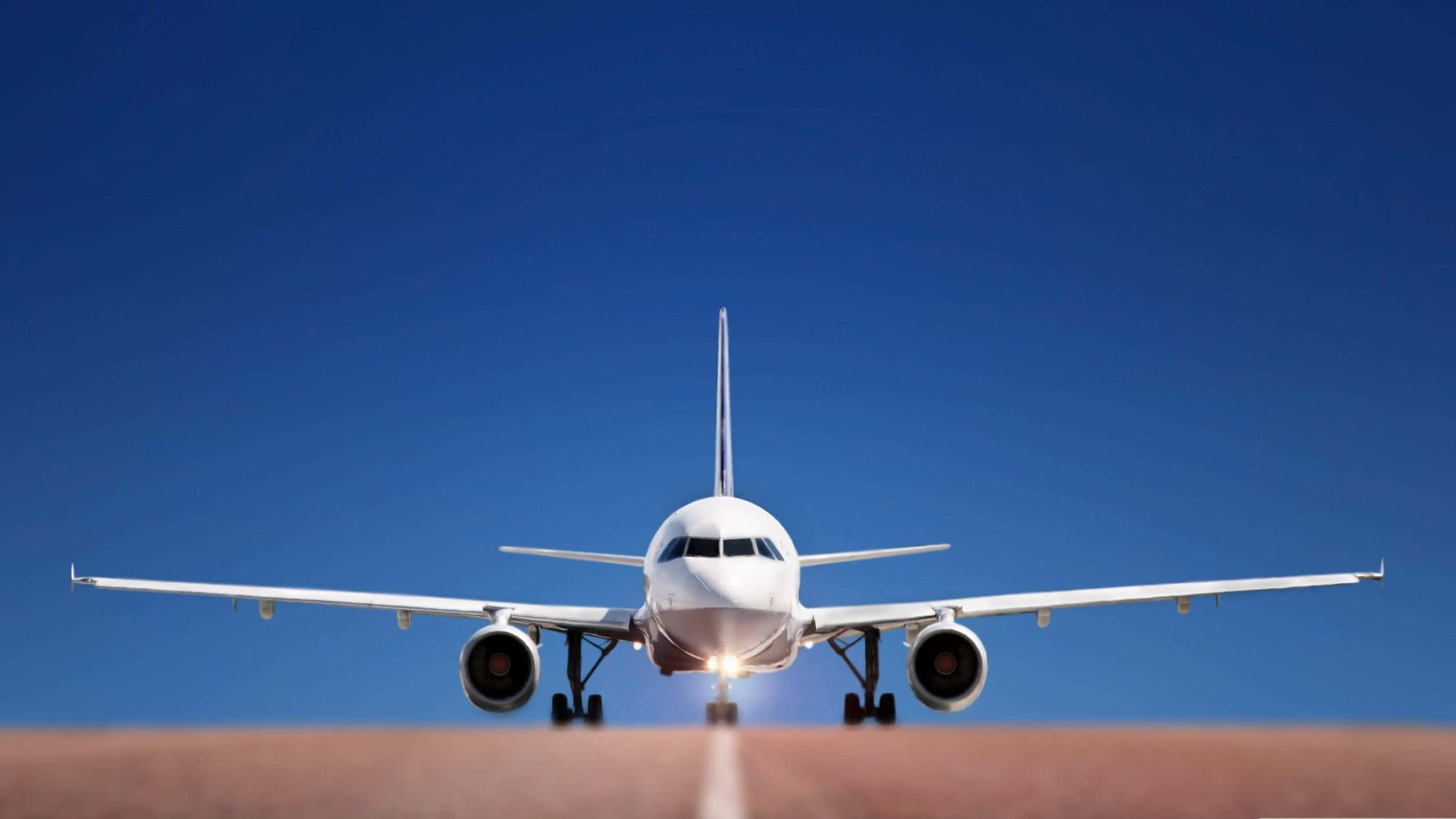 Plane 桌布 壁紙 — 一架白色客機在晴朗藍天下接近跑道，降落燈閃爍發光。