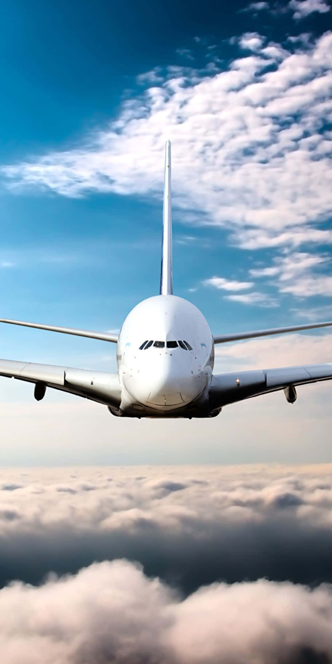 Pixel 3 Plane 桌布 壁紙 — 一架白色客機在蓬鬆的雲層上方翱翔，背景是湛藍的天空，點綴著散落的白色雲朵。
