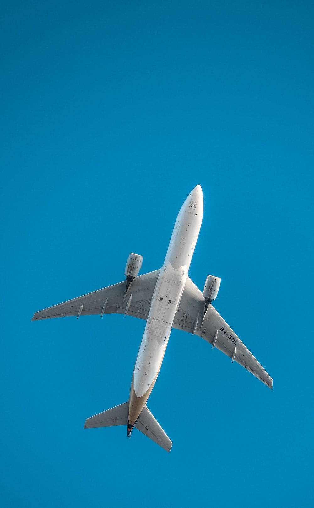 4K 飛機壁紙 桌布 壁紙 — 一架白色客機從下方仰望，在鮮豔的藍天中翱翔。