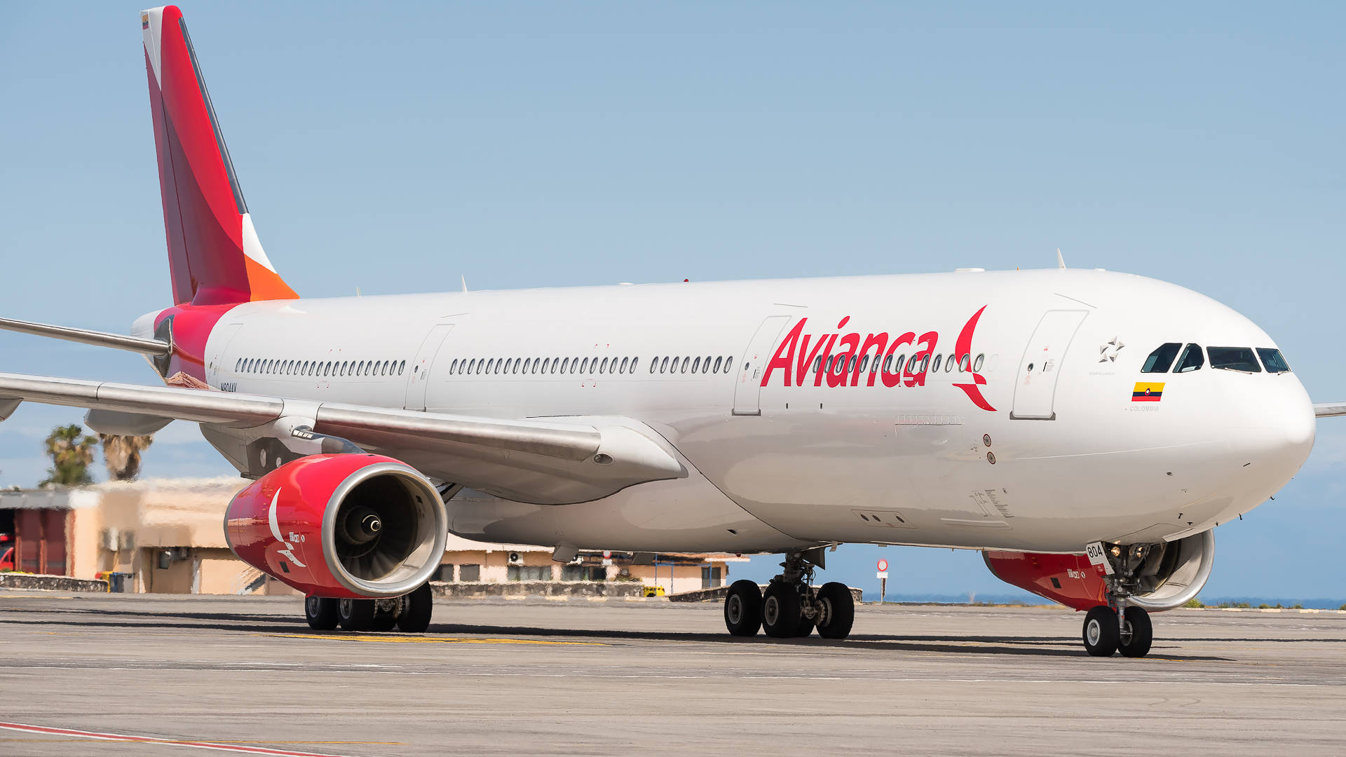 Airport 桌布 壁紙 — 一架白色的 Avianca 空中巴士 A330 帶有紅色點綴，停在機場停機坪上，背景是晴朗的藍天。