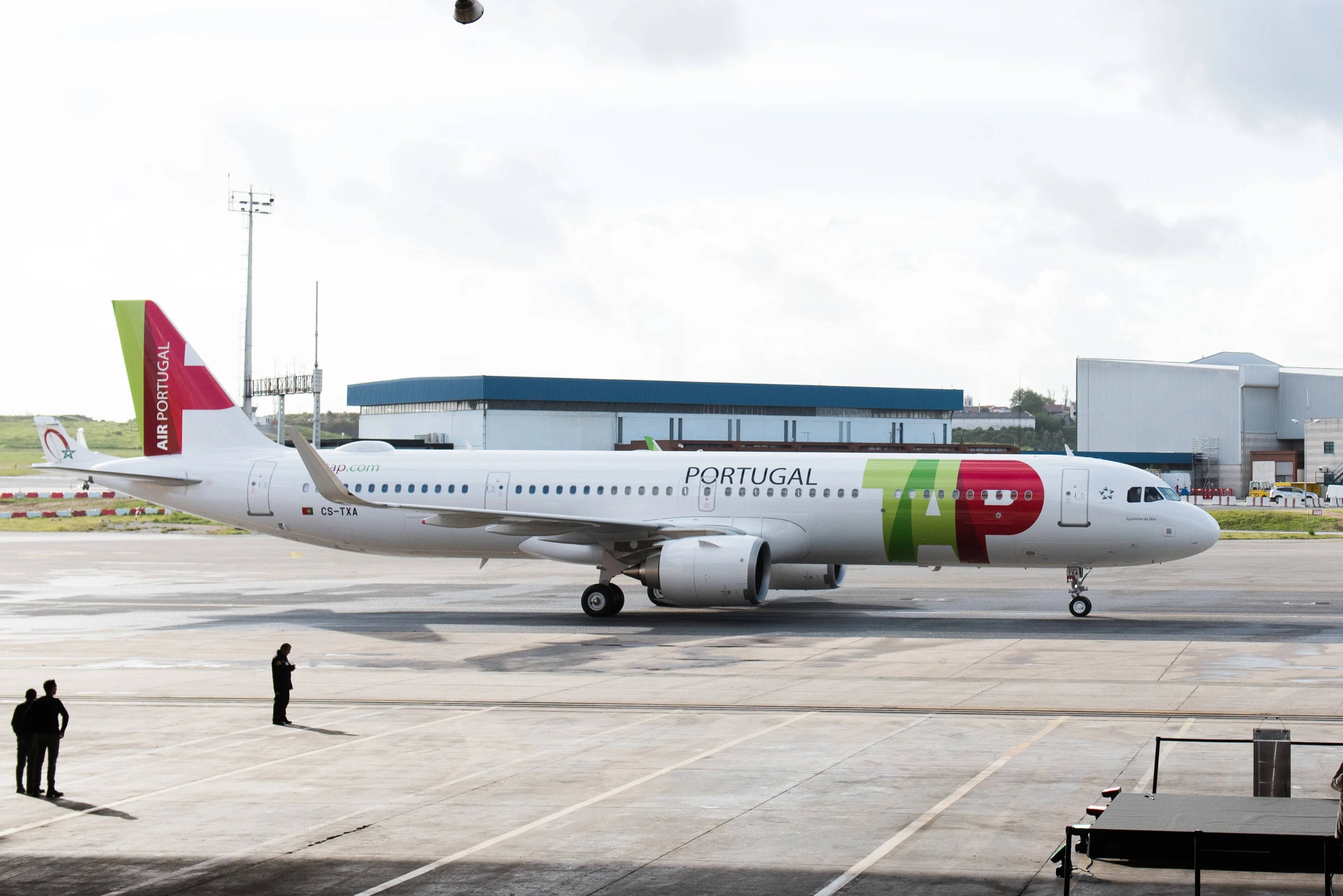 Airport 桌布 壁紙 — 一架白色的Air Portugal空中巴士A330，帶有紅綠塗裝，在多雲天空下在濕滑的機場停機坪上滑行。