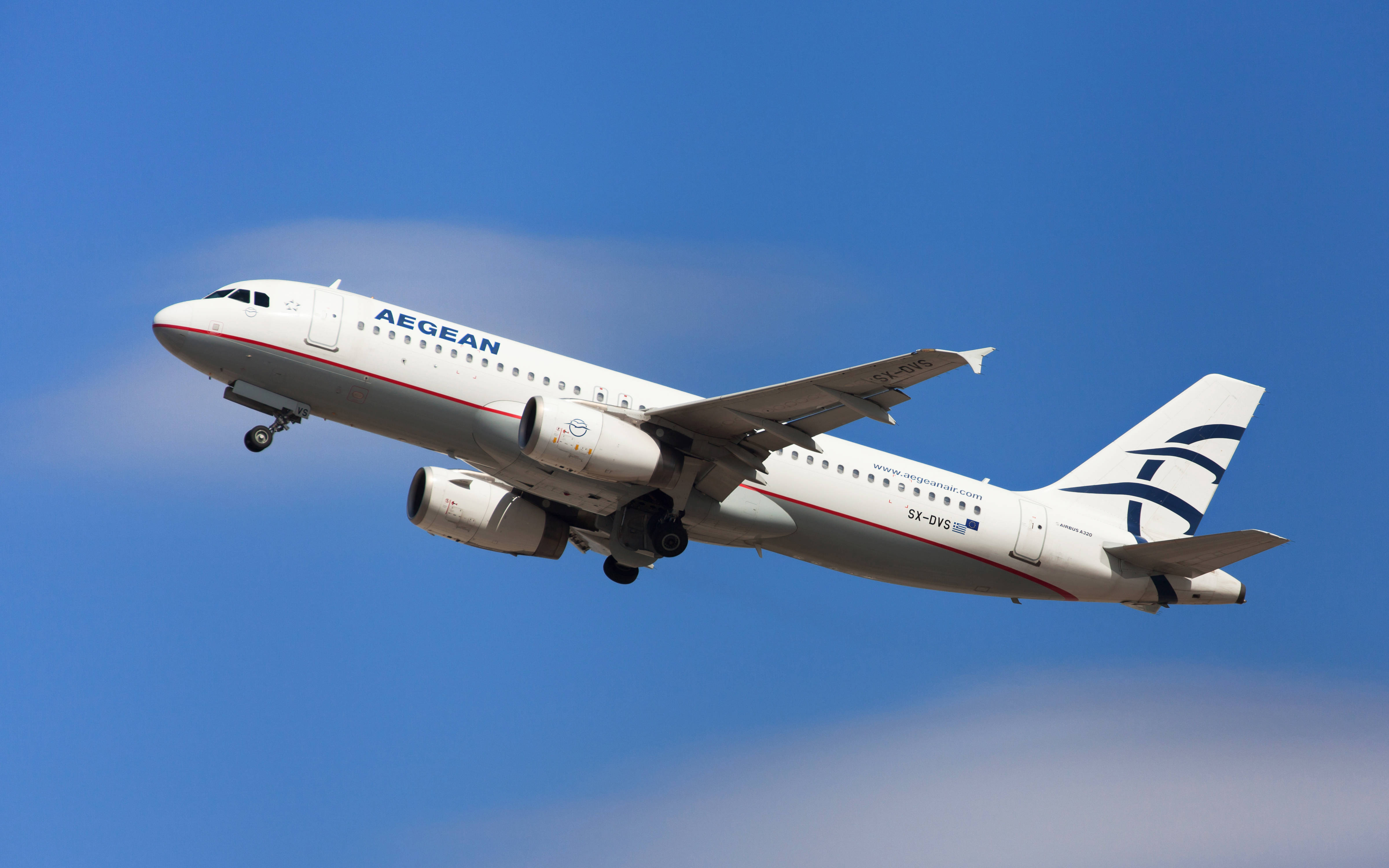 Plane 桌布 壁紙 — 一架白色的愛琴海航空空中巴士A320，起落架放下，在晴朗藍天和縷縷白雲中翱翔。