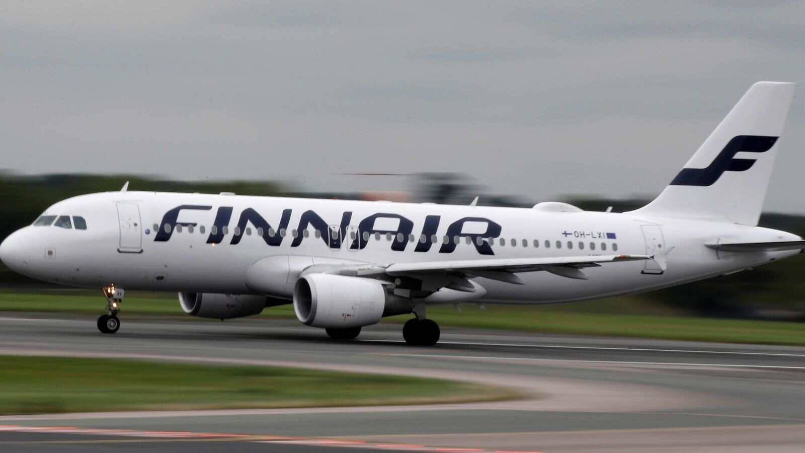 飛機 桌布 壁紙 — 一架白色的芬蘭航空空中巴士A320在跑道上滑行，背景是模糊的綠化和多雲的天空。