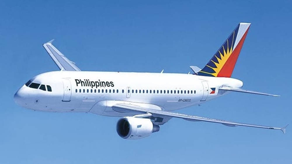 飛機 桌布 壁紙 — 一架白色的菲律賓航空空中巴士A320，以其獨特的太陽光芒尾翼設計，在清澈的藍天中優雅翱翔。