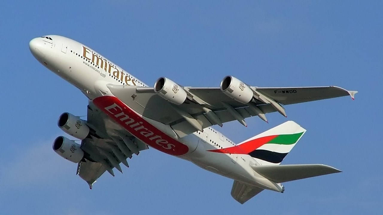 飛機 桌布 壁紙 — 一架白色的阿聯酋航空空中巴士A380在晴朗的藍天中翱翔，起落架已放下。