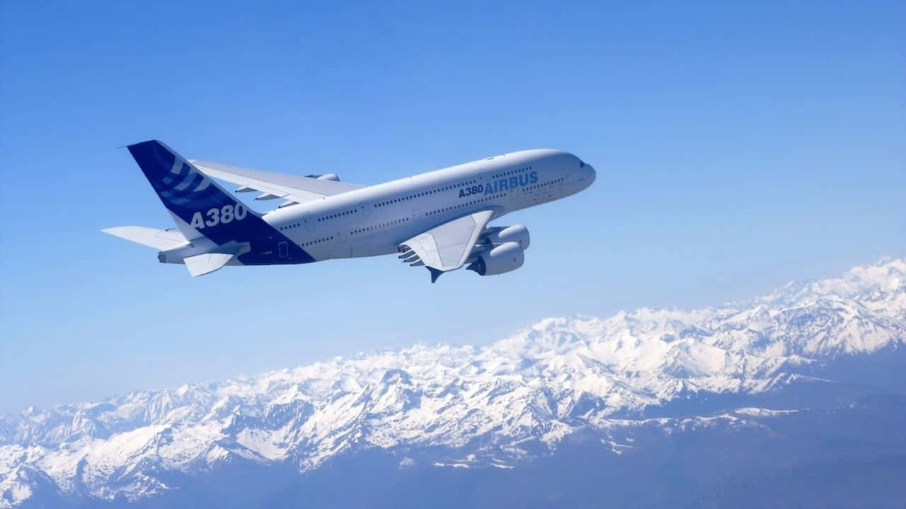 飛機 桌布 壁紙 — 一架白色空中巴士A380在晴朗藍天下翱翔於積雪山脈之上。