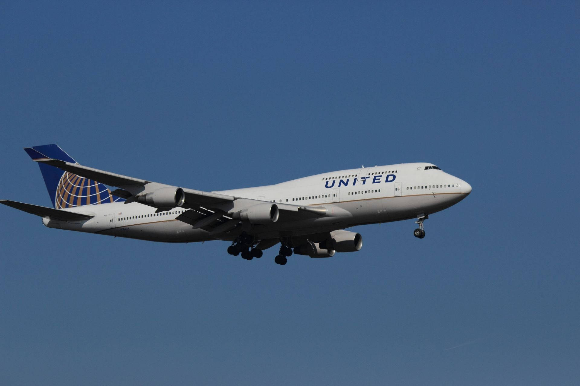 飛機 桌布 壁紙 — 一架白色聯合航空波音747放下起落架，在清澈的藍天中翱翔。