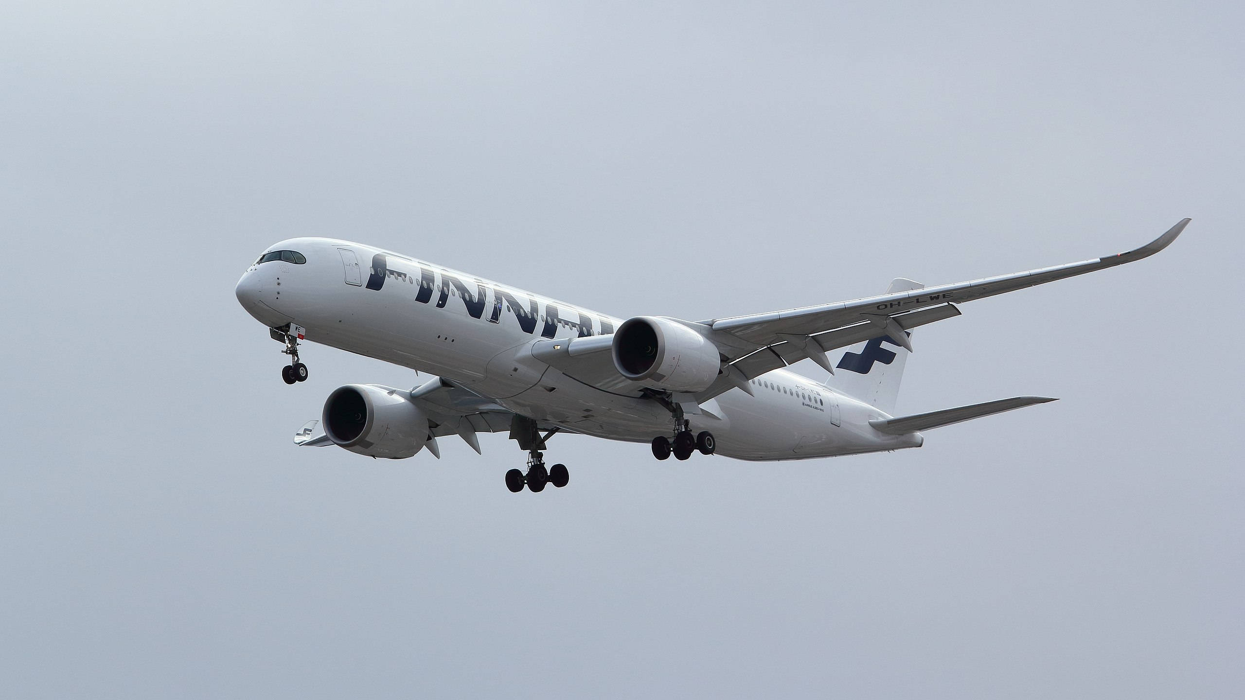 飛機 桌布 壁紙 — 一架白色芬蘭航空空中巴士A350放下起落架，在暗淡的灰色天空中翱翔。