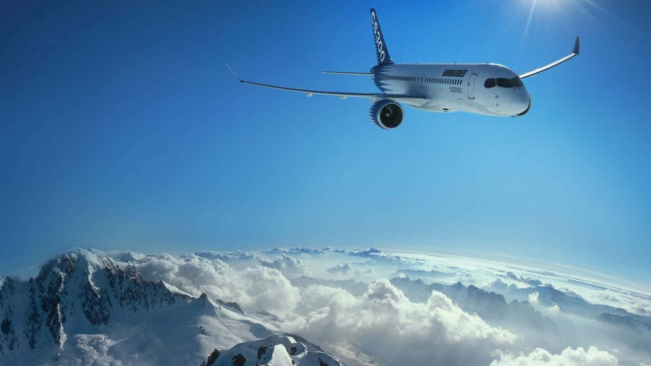 Plane 桌布 壁紙 — 一架白色飛機在白雪覆蓋的山脈和蓬鬆的雲層之上翱翔，在清澈的藍天下伴隨著陽光射線。