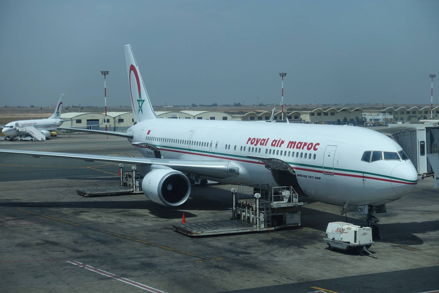 Airport 桌布 壁紙 — 一架皇家摩洛哥航空波音767停泊在機場閘口，地面服務設備和另一架飛機在背景中可見。
